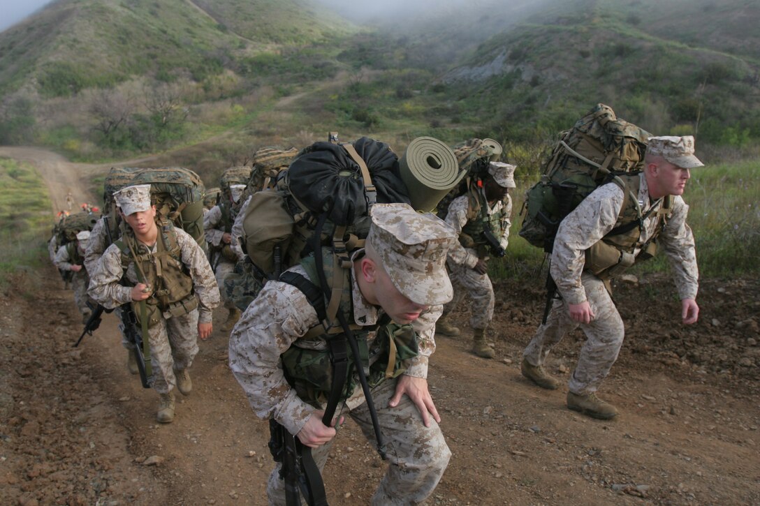 Marines with the 11th Marine Expeditionary Unit hike up a hill during a seven mile hike here March 18. The hike was the fifth that the command element conducted in recent months.