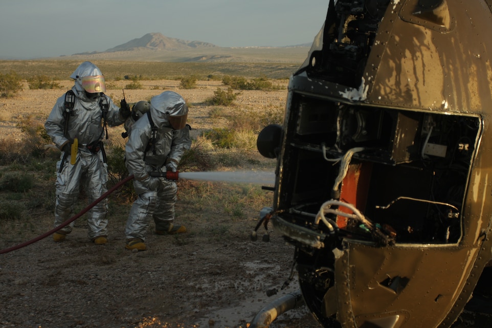 Corporals Anthony Thomas and Joshua Randall, aircraft rescue and firefighting specialists from Support Company, Marine Wing Support Squadron 374, combat a notional fire aboard a downed aircraft during a mock Tactical Recovery of Aircraft and Personnel mission March 19. The TRAP mission was part of a week-long field operation to prepare the Marines and sailors of MWSS-374 for combat operations overseas.