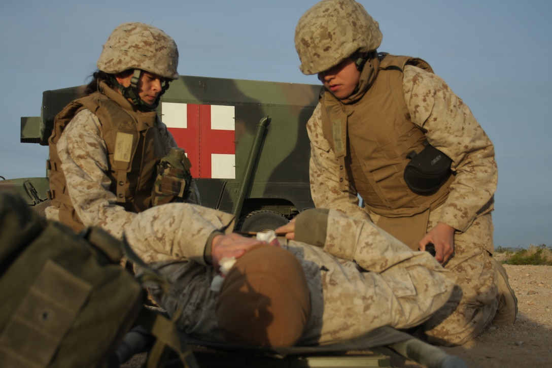 Petty Officer 2nd Class Rebecah Wolfe (left) and Petty Officer 3rd Class Andrea Daggs, hospital corpsmen with Headquarters Company, Marine Wing Support Squadron 374, load a simulated casualty onto a stretcher during a mock Tactical Recovery of Aircraft and Personnel mission March 19. The TRAP mission was part of a week-long field operation to prepare the Marines and sailors of MWSS-374 for combat operations overseas.