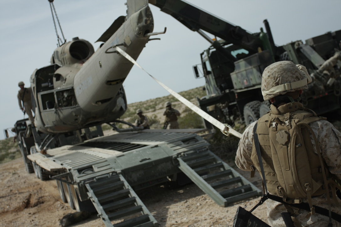 Marines from the Marine Wing Support Squadron 374 aircraft recovery team load a helicopter hulk onto a Logistics Vehicle System during a mock Tactical Recovery of Aircraft and Personnel mission March 19. The TRAP mission was part of a week-long field operation to prepare the Marines and sailors of MWSS-374 for combat operations overseas.