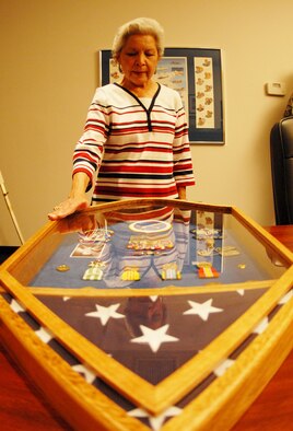 Irma Cox, examines the new shadow box donated to her by members of the 53d Wing and 33rd Fighter Wing March 18 at the Air Force Enlisted Village in Fort Walton Beach, Fla.  The shadow box contains medals and military mementos of her late husband, Senior Master Sgt. John Cox, a 28-year Air Force veteran.  U.S. Air Force photo/ Samuel King Jr.
