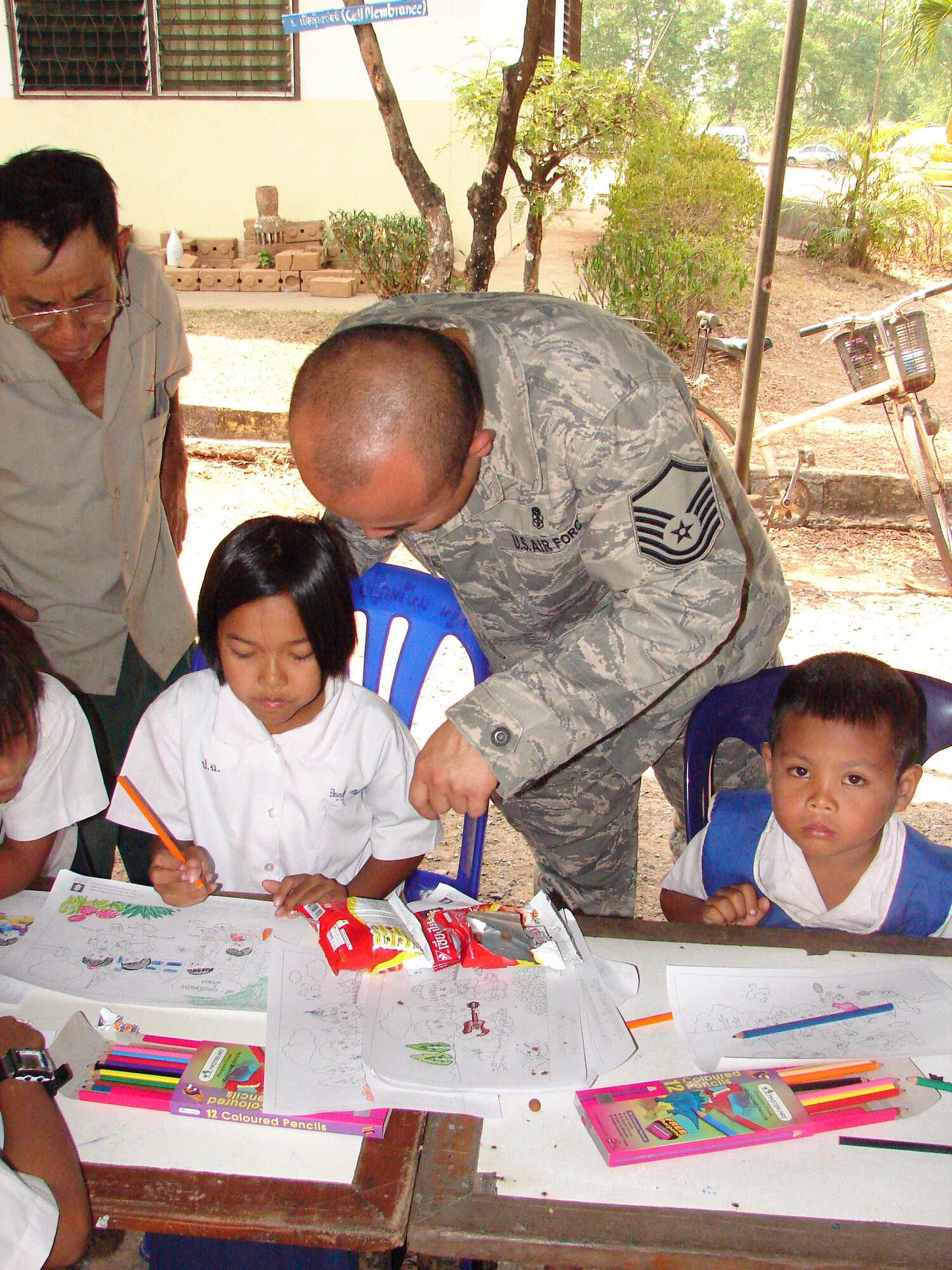 Master Sgt. Siamrad Maher talks with a student at the Ban Pong Dang
Namcha Samakkhi School about her art project.  The students of the school
got a holiday from classes while U.S., Thai and Singaporean military
personnel conducted a medical civic action outreach day as part of Cope
Tiger 2009, an annual, multinational, large forces aerial exercise which has
aerial and humanitarian portions in and near both Korat and Udon Thani,
Thailand.  Sergeant Maher was born in Nong Pai Lom, a village nearby.

