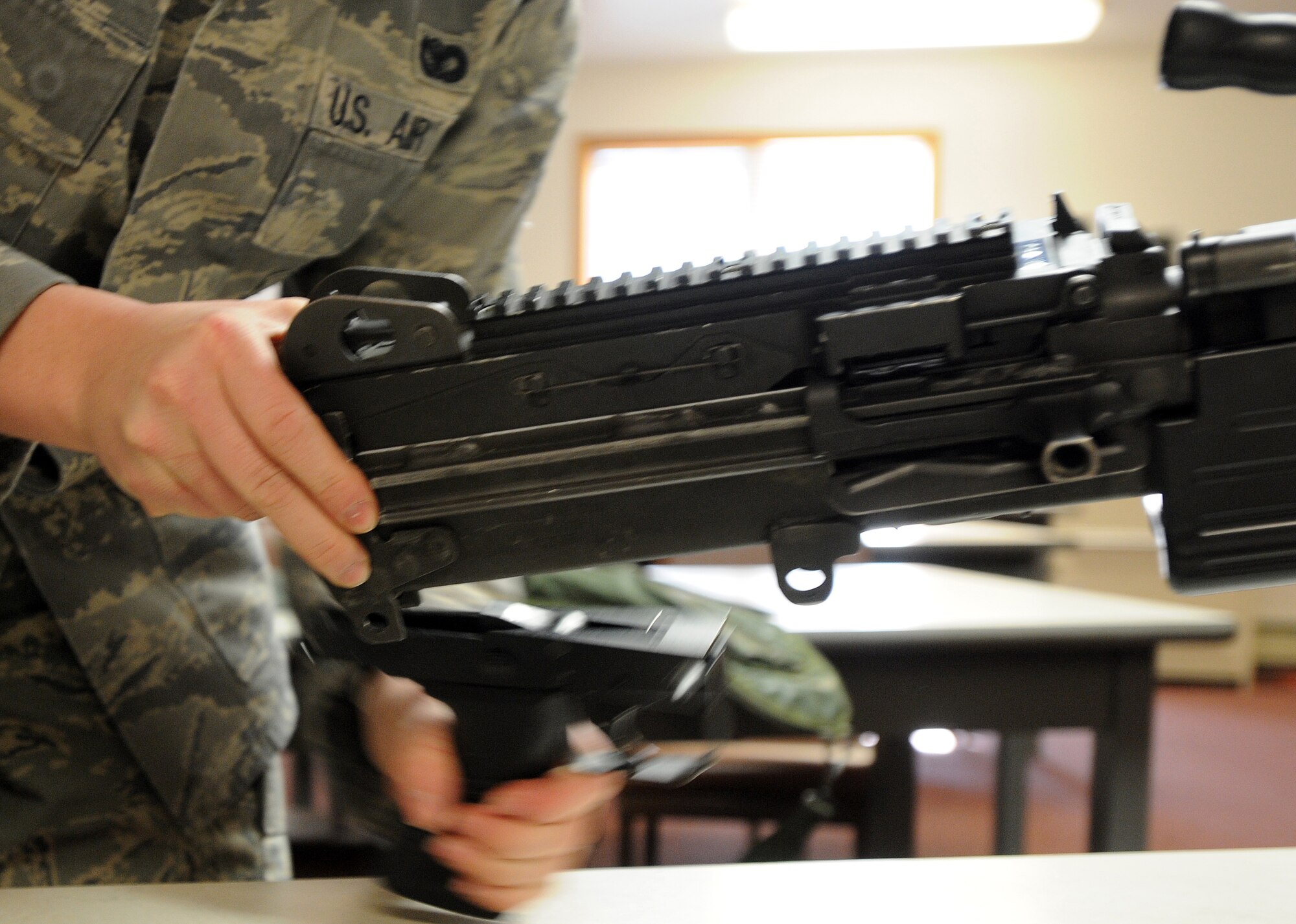An Airman from the 354th Security Forces Squadron removes the trigger assembly from an M249 automatic rifle during a qualification course March 13, 2009, Eielson Air Force Base, Alaska. During the course students are briefed on the weapons specifications, components, functions, and implications on today's battlefield. (U.S. Air Force photo/Airman 1st Class Willard E. Grande II)