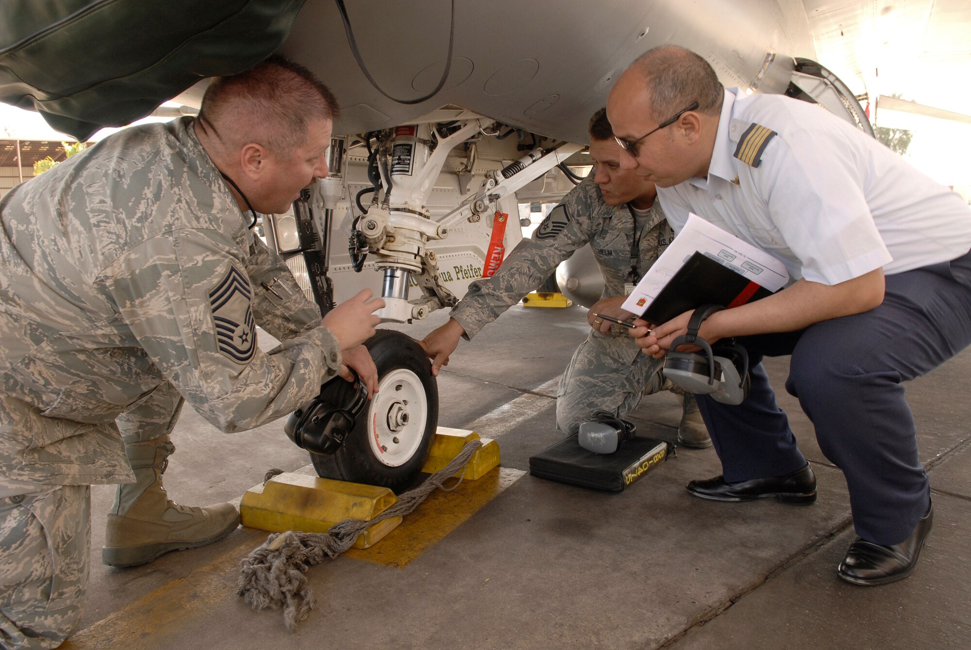 Chief Master Sgt. Robert Britton and Master Sgt. Michael Helm discuss features of the F-16 Fighting Falcon nose landing gear with a member of the Royal Moroccan air force March 12 at Luke Air Force Base, Ariz. Members of the Royal Moroccan air force visited Luke AFB to learn about Air Force maintenance procedures. Chief Britton and Sergeant Helm are assigned to the 310th Aircraft Maintenance Unit. (U.S. Air Force photo/Staff Sgt. Ian Dean) 
