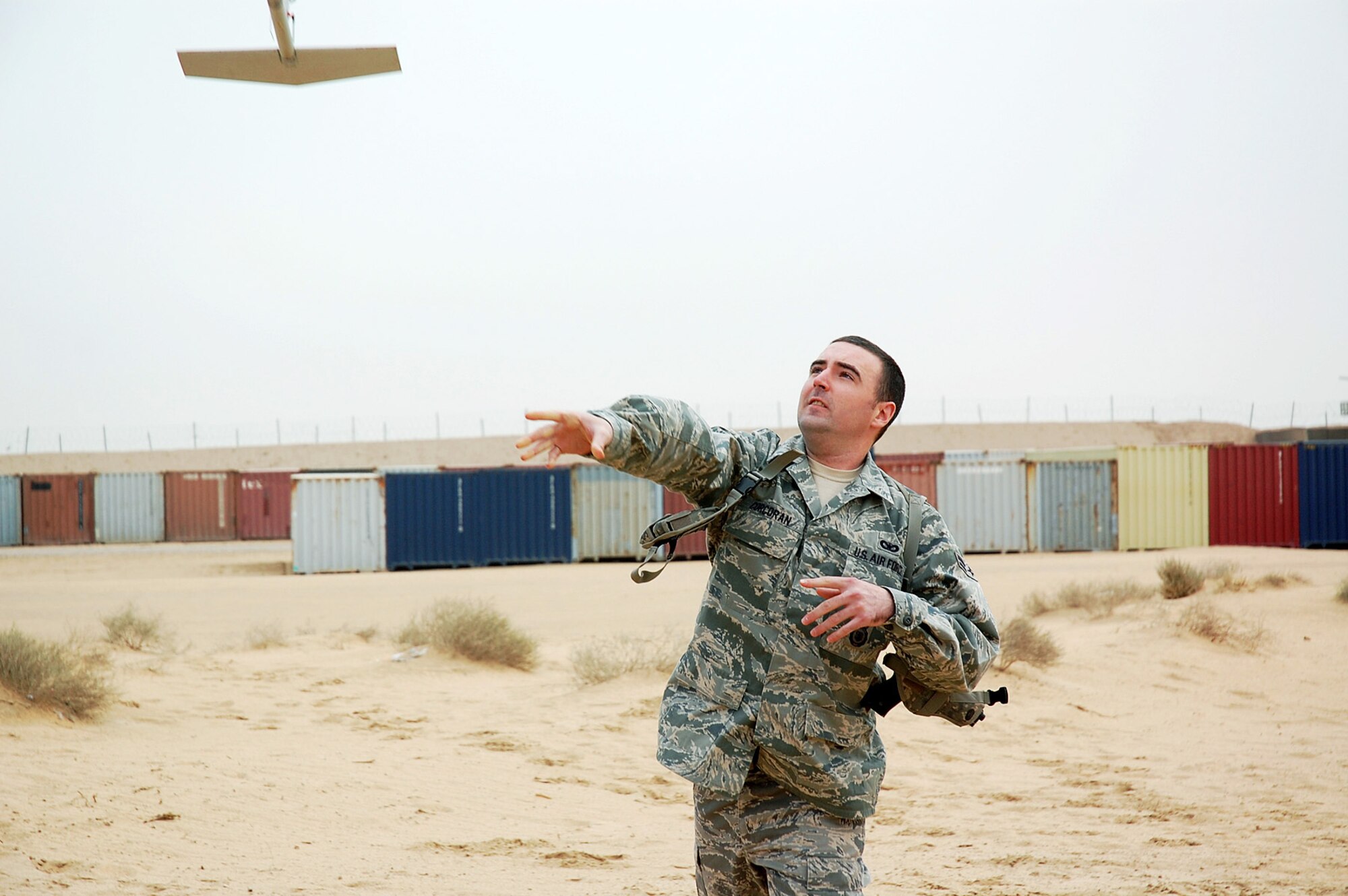 Airman 1st Class Shane Corcoran launches an RQ-11B unmanned aircraft system from Camp Bucca's Burge Field in Iraq Feb. 25. Requiring neither runway nor launcher, the Raven B is ideal for tactical-level intelligence, surveillance and reconnaissance missions. Everything needed to operate the system can fit into a rucksack, and the UAS itself can be launched by hand or from a vehicle. Airman Corcoran is an 887th Expeditionary Security Forces Squadron Raven B operator. (U.S. Air Force photo/Staff Sgt. Thomas J. Doscher)