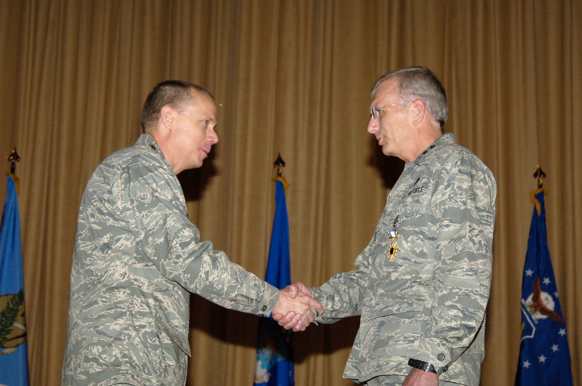 Gen. Donald Hoffman, commander of the Air Force Materiel Command, held a town hall meeting at Tinker March 13. The general discussed his priorities for the command and spoke of properly recognizing outstanding performers. He then surprised Oklahoma City Air Logistics Center Commander Maj. Gen. P. David Gillett Jr., right, with the Distinguished Service Medal. (Air Force photo/Margo Wright)