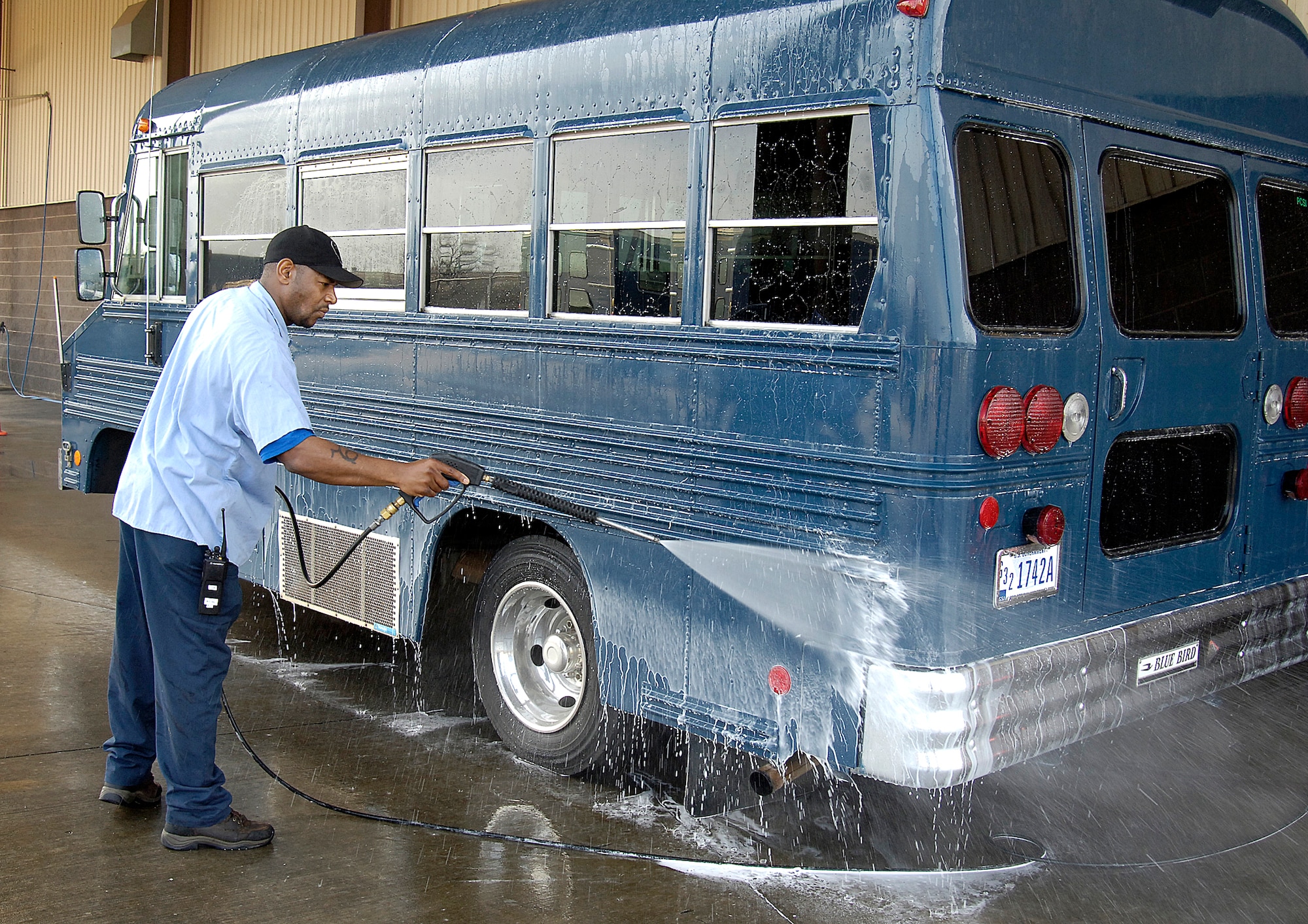 Darrell Cooks returns the shine to a bus in the wash bay of the 72nd LRS facility.  Heavy use and dirty conditions keep Mr. Cooks busy ensuring clean, fueled vehicles are ready for a host of customers. (Air Force photo/Margo Wright) 