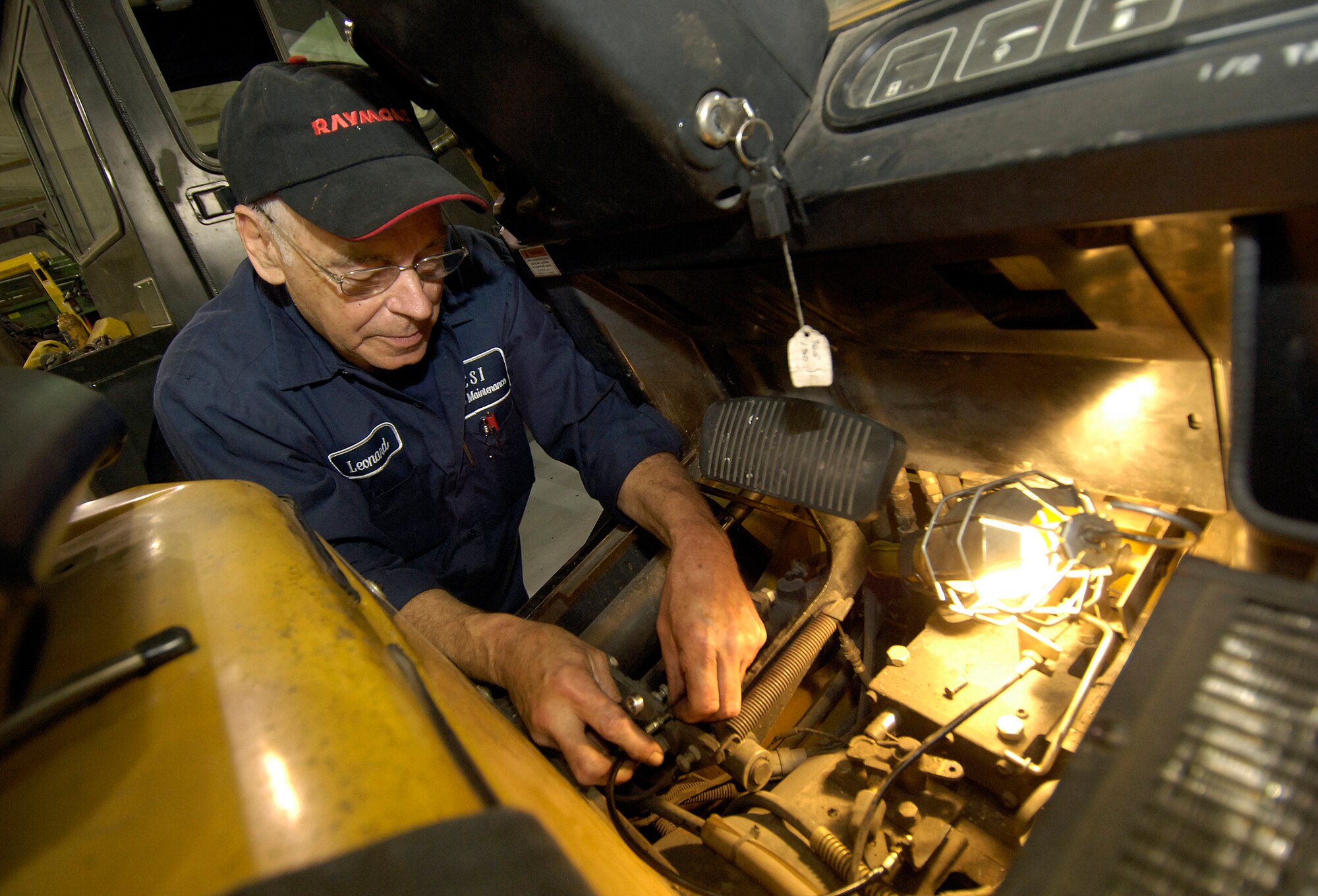 A forklift’s brake cable is repaired by Leonard Payne, who specializes in forklifts, but has repaired a host of vehicles during his 25-year Tinker career. (Air Force photo/Margo Wright) 