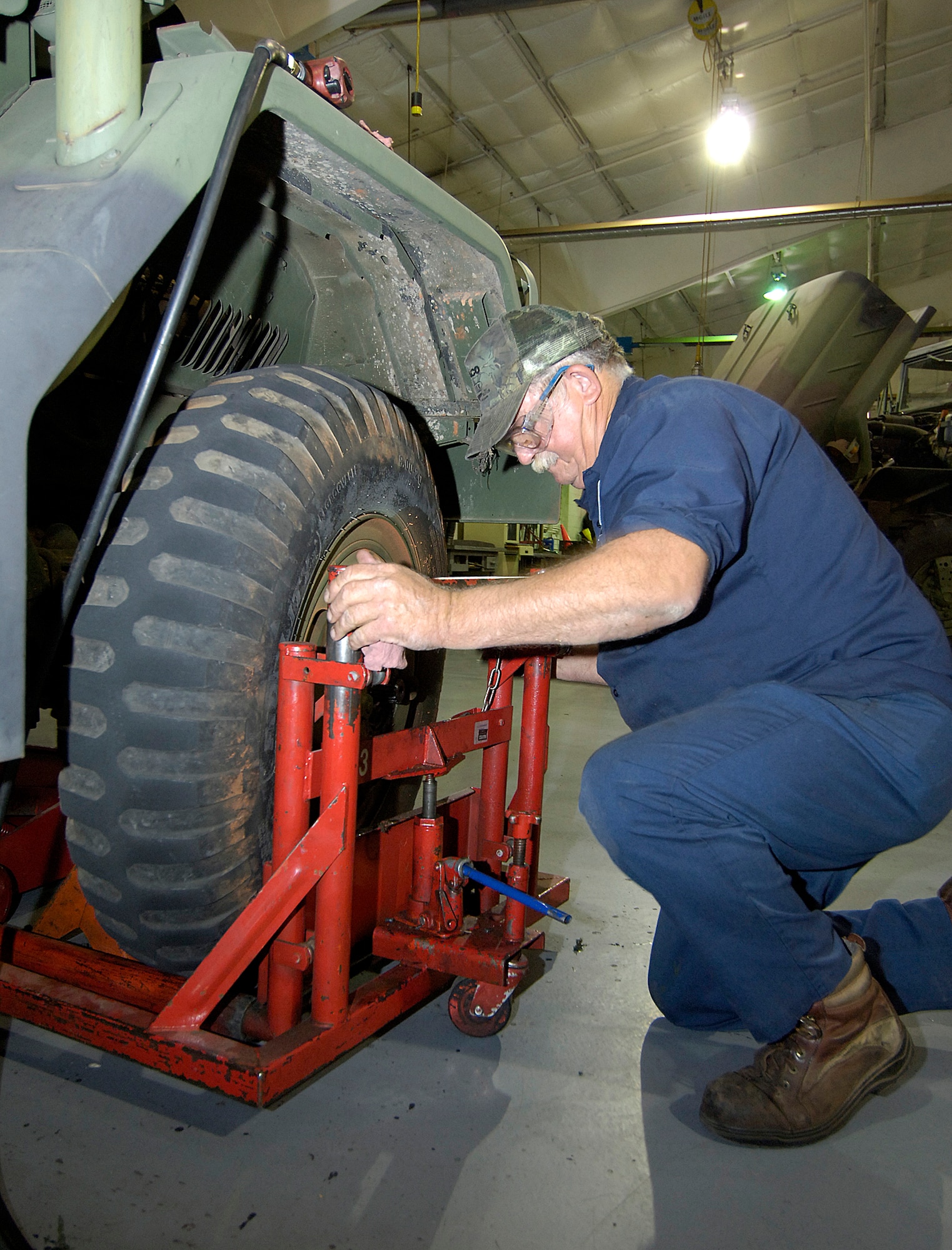 James Estep muscles a tire from an M-35 cargo truck during clutch replacement work in a bay of the 72nd Logistics Readiness Squadron’s maintenance area. Forklifts, hulking camouflaged-painted cargo trucks, and fire trucks are a variety of vehicles the mechanics repair in Bldg. 1130 near the Gott Gate. (Air Force photo/Margo Wright) 