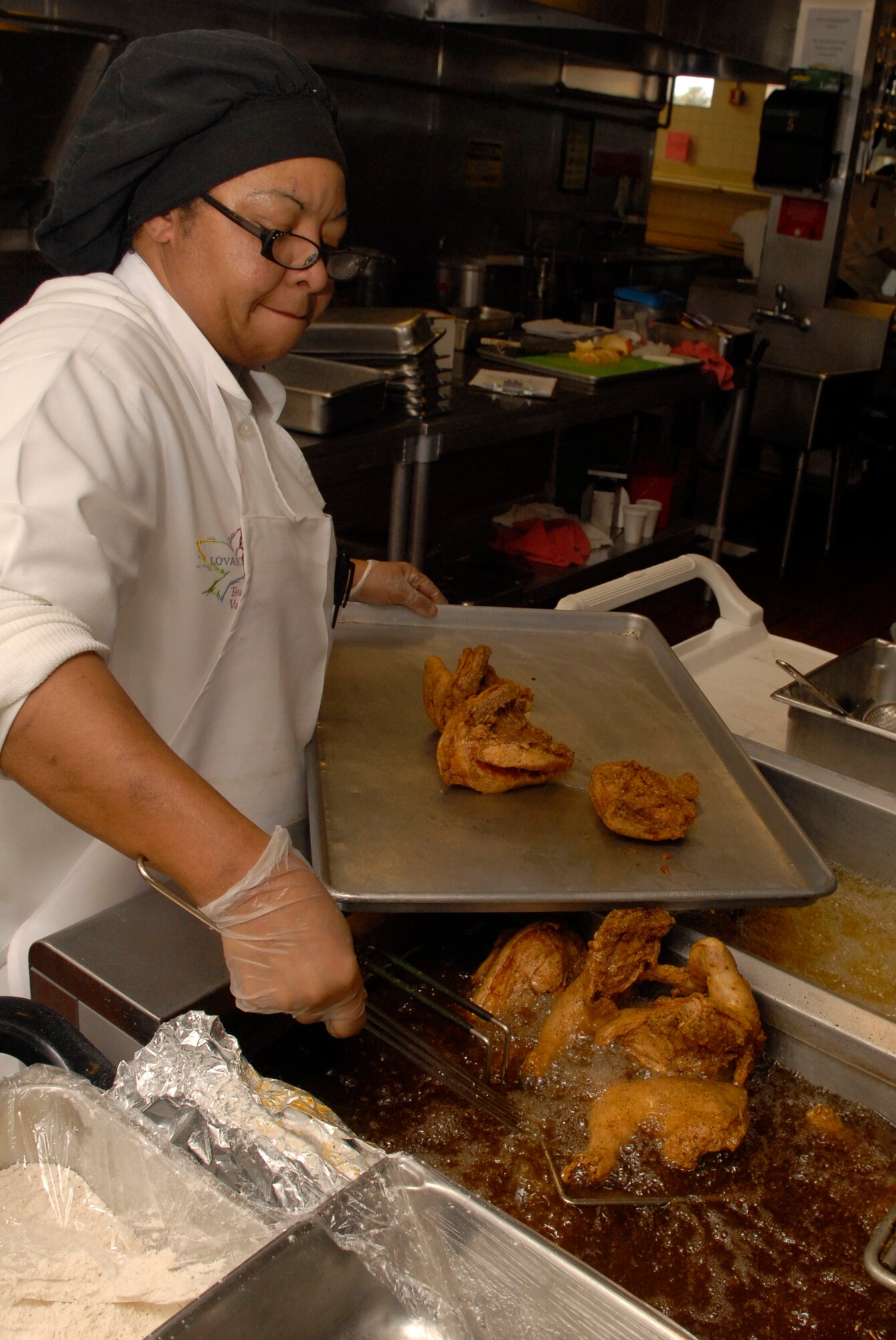 VANDENBERG AIR FORCE BASE, Calif. -- Betty Conley, a lead cook at Breakers Dining Facility, moves baked chicken using a utensil March 18. The facility is responsible for providing the nutrition Airmen need to perform their duties by being both healthy and affordable. (U.S. Air Force photo/Senior Airman Christian Thomas)