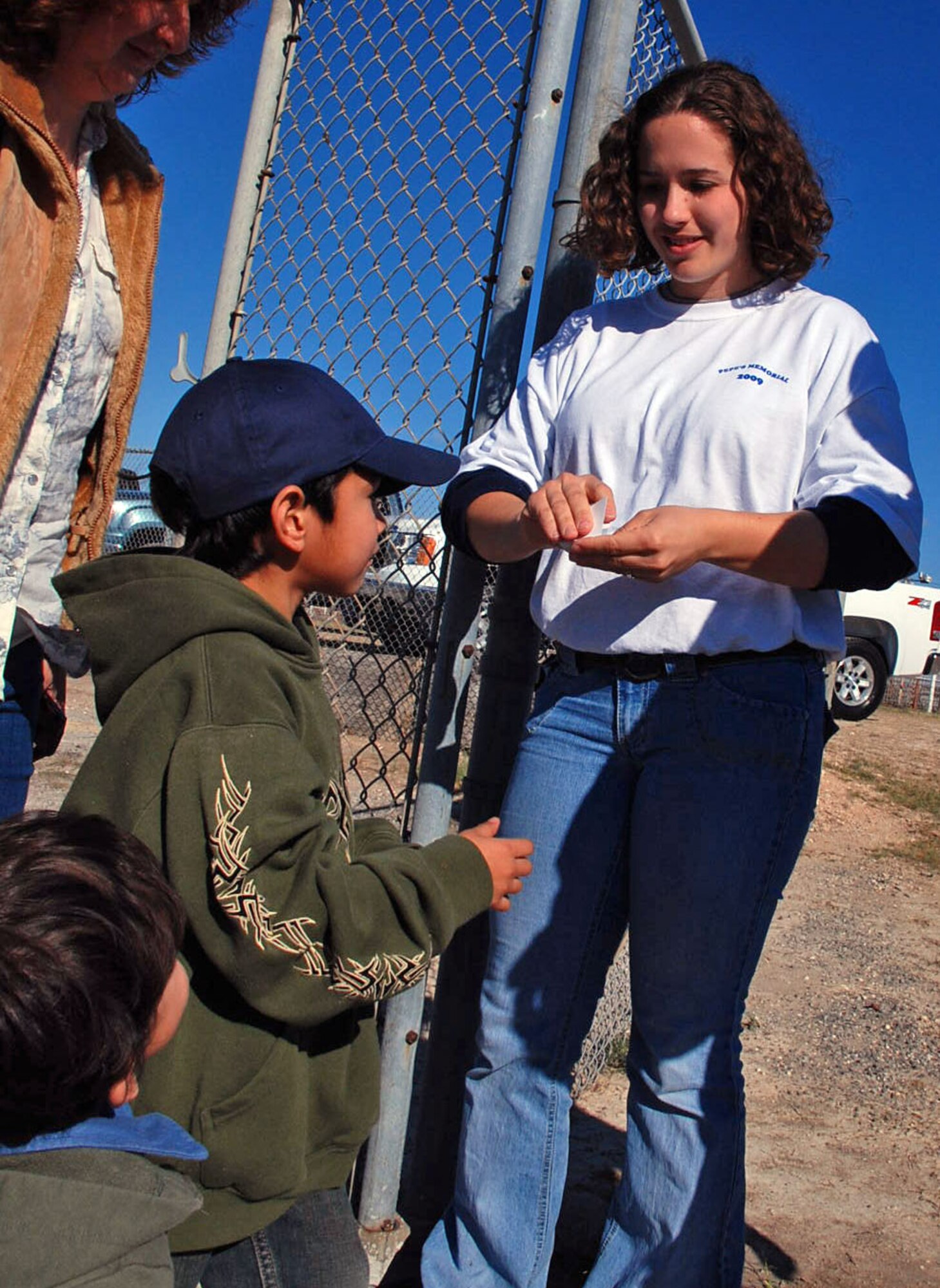 LAUGHLIN AIR FORCE BASE, Texas -- Airman 1st Class Christina Gallagher, 47th Flying Training Wing Contracting Squadron, takes tickets at the main entrance for the Airman Pepe Hernandez Memorial Bull Riding Bash at the Val Verde County Fairgrounds in Del Rio, March 15. Airman Gallagher was one of 23 Laughlin volunteers who to help raise money in their off-duty time for the children of Airman Hernandez. (U.S. Air Force photo by Tech. Sgt. Charlie Miller)