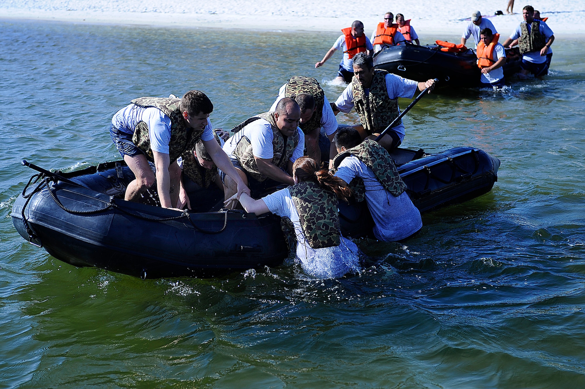 Airman Leadership School students pull a team member into a boat for the last leg of the Monster Mash Challenge here Mar. 17. The Monster Mash is competition designed to build leadership skills and teamwork, where ALS students square off against ALS instructors and Chief's Group members for a hands-on application of skills they've learned during their classroom time. It has been a regular part of the Hurlburt ALS curriculum for almost a year. (U.S. Air Force photo/Senior Airman Julianne Showalter)