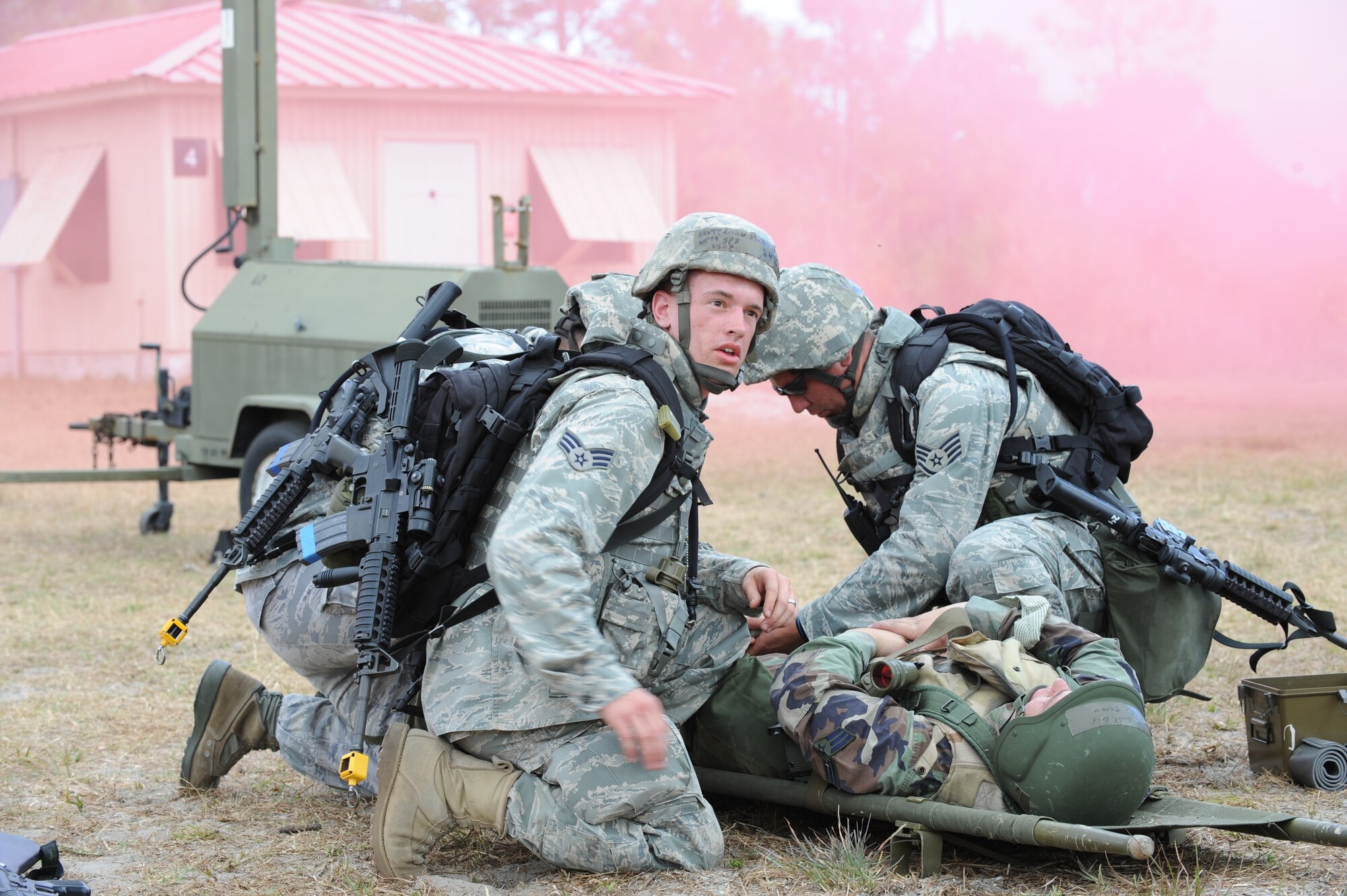 Members of the 45th Security Forces Squadron perform Self-Aid and Buddy Care to a wounded member after a simulated attack with smoke still visible at the Malabar Training Annex during the recent weeklong Operation Ocean Breeze deployment exercise. (U.S. Air Force photo/John Connell)
