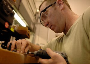 Staff Sgt. Nathan Lett designs and implements a high voltage discharge device March 18 on Charleston AFB. The high voltage discharge device allows personnel in the maintenance section of the 1st Combat Camera squadron to safely work on photographic equipment and ensure mission success. Sergeant Lett is a combat visual imagery and intrusion detection systems craftsman with the 1CTCS. (U.S. Air Force photo/Senior Airman Katie Gieratz)