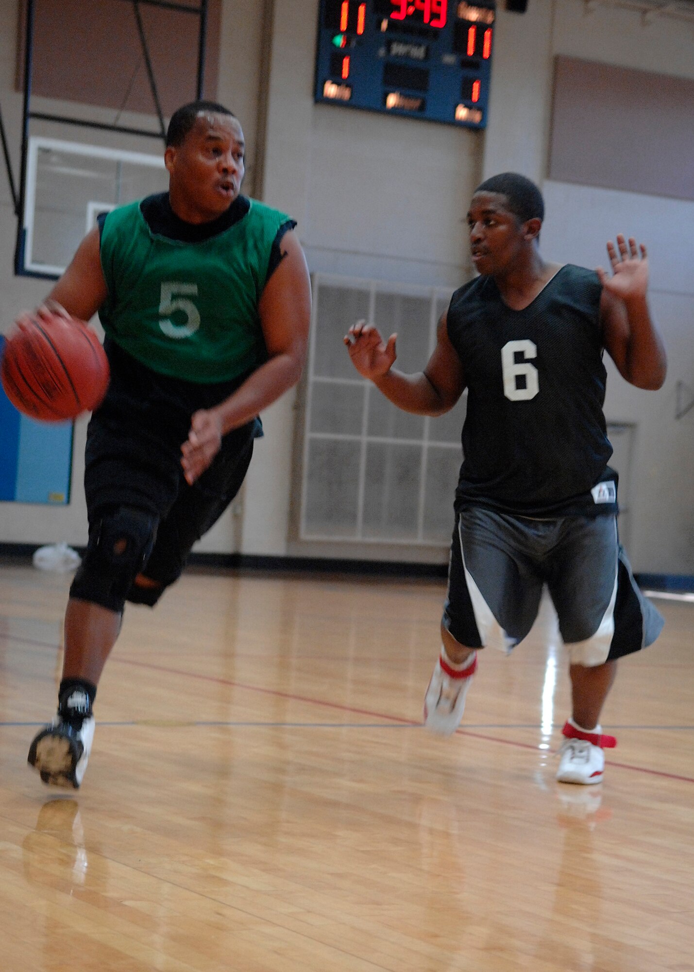 Johnny Glasgow dribbles the ball as Terrance McKelvey attempts to guard him during the intramural basketball game at the Fitness and Sports Center here Mar. 18.  AMXS defeated the SFS team 50-46. Glasgow is with the 437th Aircraft Maintenance Squadron and McKelvey is with the 437th Security Forces Squadron. (U.S. Air Force photo/Senior Airman Katie Gieratz)
