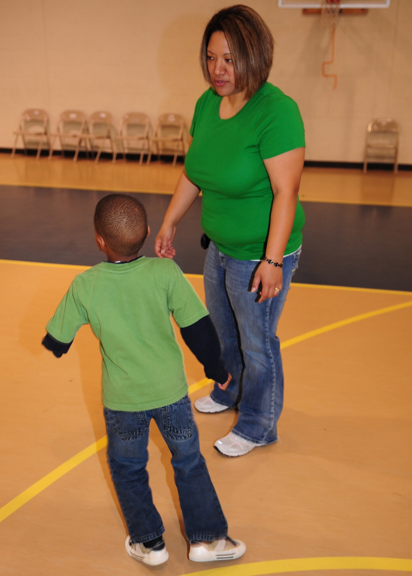 Natasha Fukushima, after school care provider, talks to one of her students in the base youth center's after-school program at Seymour Johnson Air Force Base, N.C., March 17, 2009. Ms. Fukushima was nominated for the School-Age NOTES Foundation's Quest for Excellence Award. In order to be nominated for the award a staff member needs to work directly with the children every day in an after-school program for at least two years. (U.S. Air Force photo by Airman 1st Class Rae Perry)