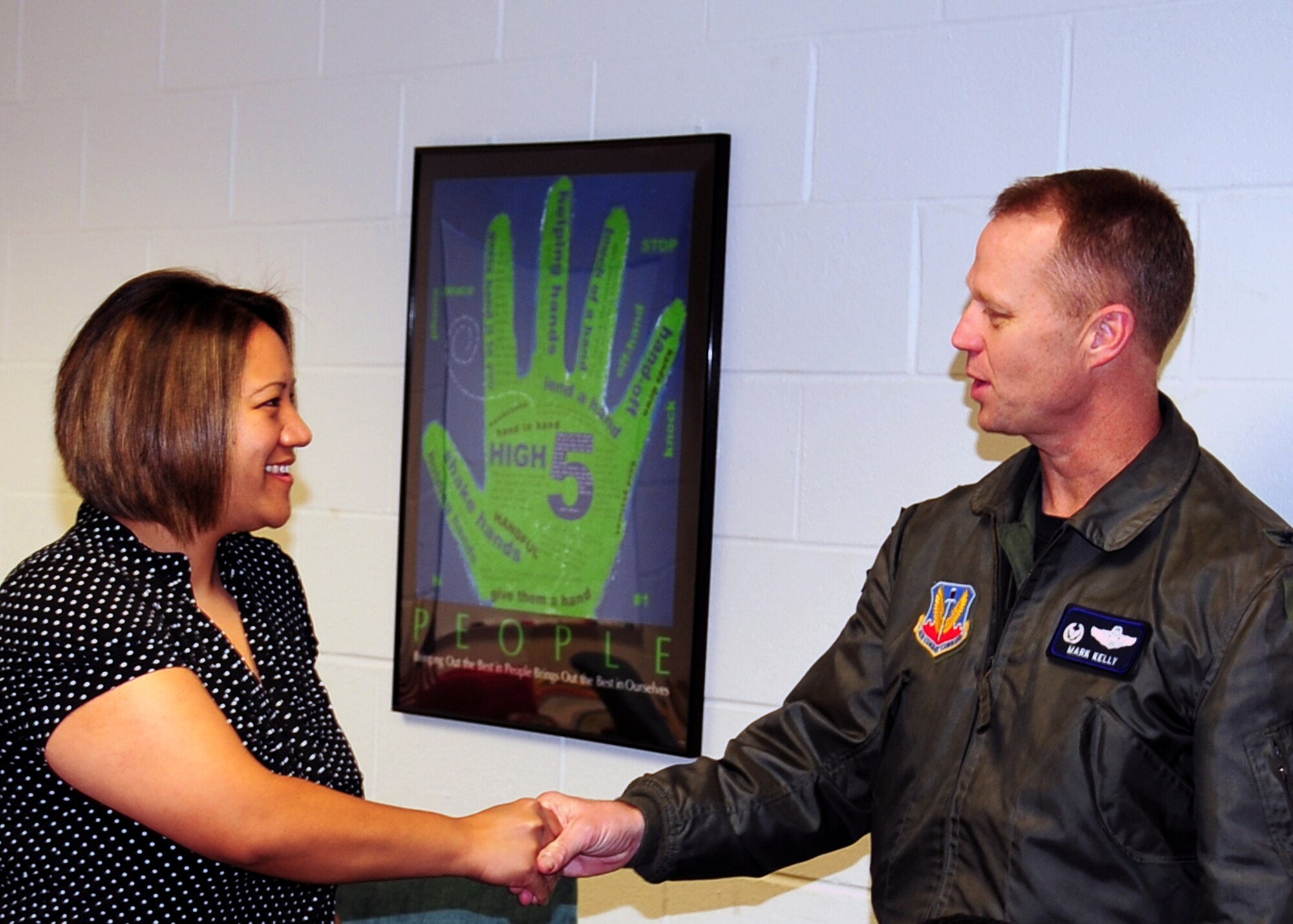 Col. Mark Kelly, 4th Fighter Wing commander, presents Natasha Fukushima, after-school care provider, with a commander's coin for her work as an educator at Seymour Johnson Air Force Base, N.C., March 17, 2009. Ms. Fukushima was selected as an Air Force top-five nominee for the School-Age NOTES Foundation's Quest for Excellence Award. The NOTES foundation is a publishing and retailing company that provides resources for after-school programs. (U.S. Air Force photo by Airman 1st Class Rae Perry) 