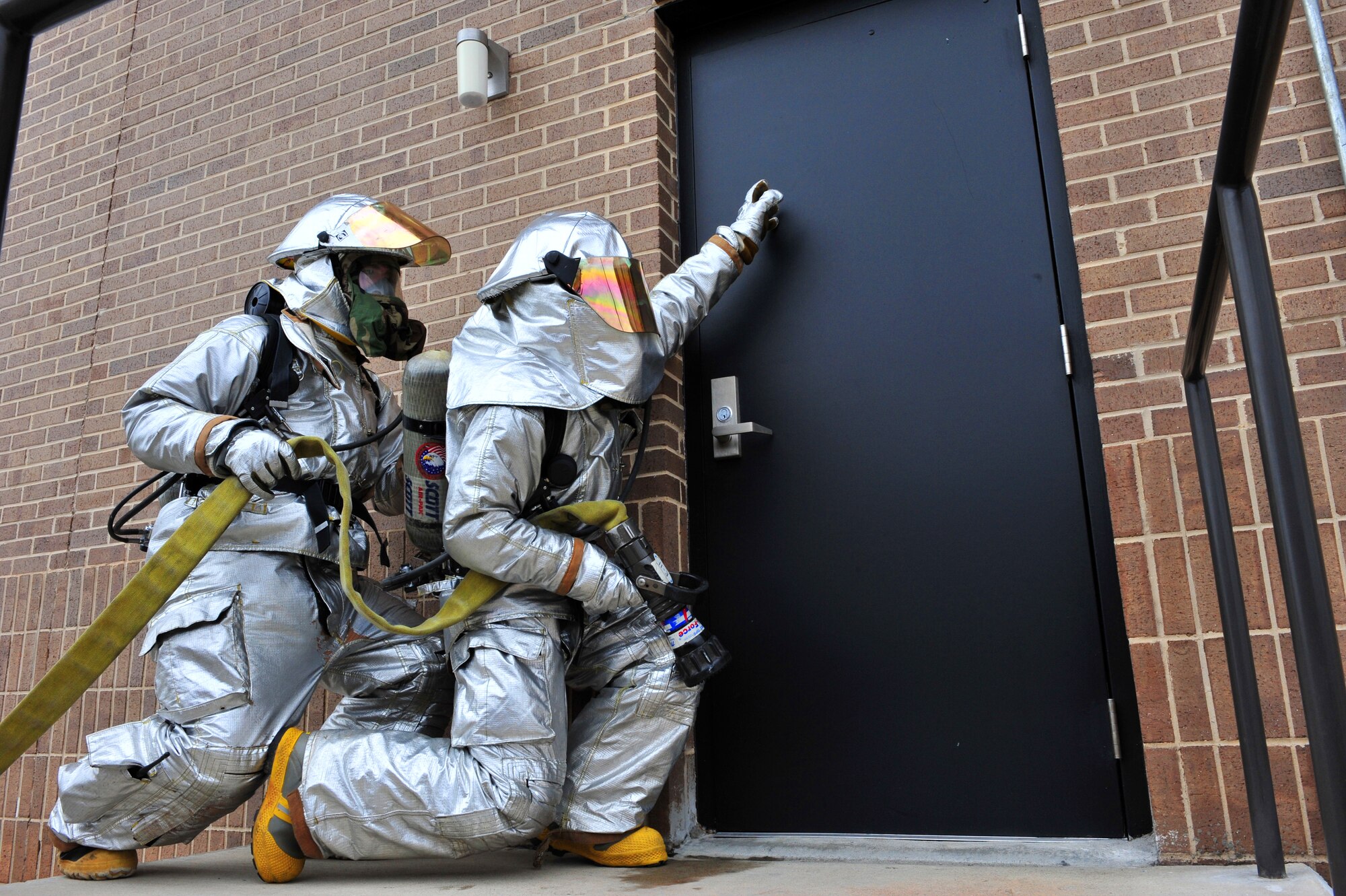 SHAW AIR FORCE BASE, S.C.- Airman Justin Salzman, 20th Civil Engineer Squadron firefighter, checks for intense heat coming from the door of a simulated building fire while Staff Sgt. Richard Davis, 20th CES firefighter, provides support during an operational readiness exercise, March 17, 2009. This ORE is crucial to Shaw's preparation for an upcoming operational readiness inspection in June. (U.S. Air Force Photo by Senior Airman William Coleman)
