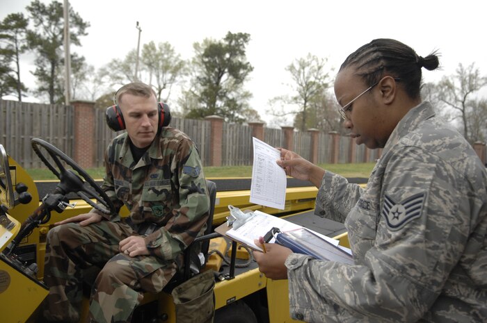 Staff Sgt. Alanda Caldwell inspects a safety function checklist while Senior Airman Joshua Bounds waits for final approval March 17. The 437th Logistics Readiness Squadron conducted a vehicle roll by inspection for the upcoming Unit Compliance Inspection. Sergean Caldwell is from the 437 LRS and Airman Bounds is from the 437th Aerial Port Squadron. (Air Force photo/James Bowman)
