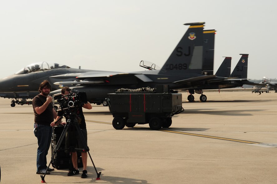 Two cameramen film aircraft maintainers interacting with mechanics from Richar Petty Motorsports at Seymour Johnson Air Force Base, N.C., March 11, 2009. The video will show the parallels between Air Force and NASCAR jobs. (U.S. Air Force photo by Airman 1st Class Rae Perry)