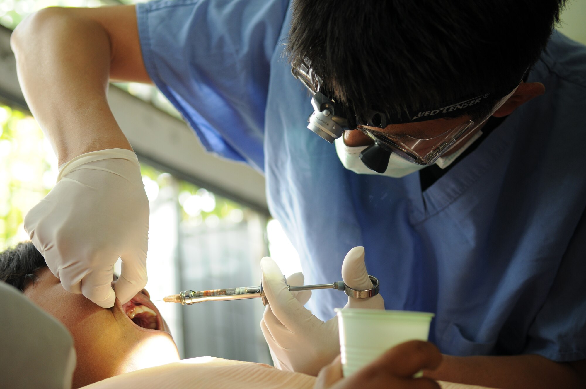 Capt. Brett Chung, a Dentist from the 374th Dental Squadron, Yokota Air Base, Japan, performs a tooth extraction during a joint and multinational humanitarian mission to provide much needed dental care to Thailand's underprivileged during Cope Tiger 2009 on March 16.  

Cope Tiger is an annual exercise held in Thailand to improve combat readiness and combined and joint interoperability of U.S., Thai and Singaporean forces while enhancing regional security and providing humanitarian support.
(U.S. Air Force Photo/Staff Sgt. Angelique Perez) 