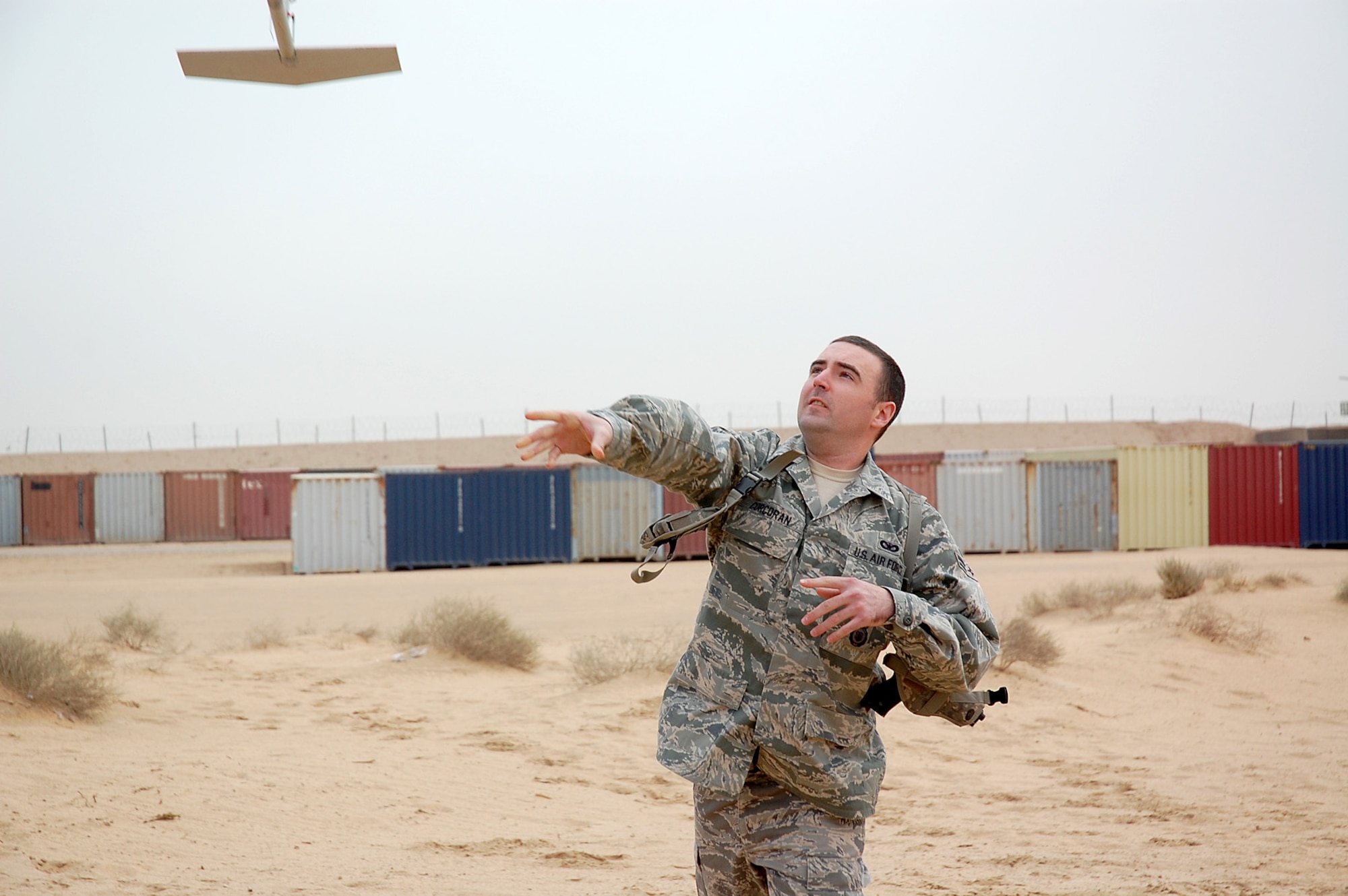 CAMP BUCCA, Iraq -- Airman 1st Class Shane Corcoran, 887th Expeditionary Security Forces Squadron Raven B operator, launches an RQ-11B unmanned aerial system from Camp Bucca's Burge Field Feb. 25. Requiring neither runway nor launcher, the Raven B is ideal for tactical-level intelligence, surveillance and reconnaissance missions. Everything needed to operate the system can fit into a rucksack, and the UAS itself can be launched by hand or from a vehicle. (U.S. Air Force photo by Staff Sgt. Thomas J. Doscher)