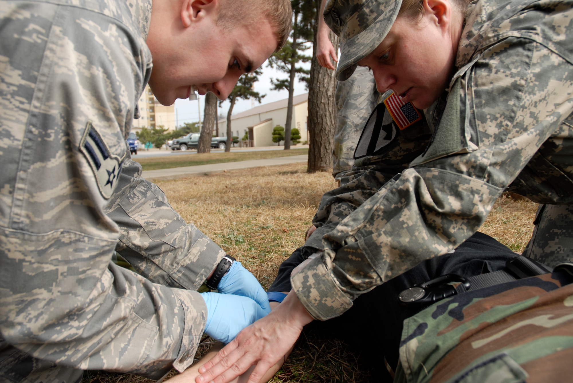 Army Sgt. 1st Class Pamela Whitmire, assigned to the 45th Air Defense Artillery, Headquarters, Headquarters Battery out of Camp Carol, Republic of Korea, instructs Airman 1st Class Nick Adkisson, 8th Civil Engineer Squadron, as he gives an intra-venus drip to Senior Airman Nathan Miller, 8 CES, during a Combat Life Saver training course at Kunsan Air Base, Republic of Korea, Mar. 19, 2009. (U.S. Air Force Photo by SSgt Jason Colbert)