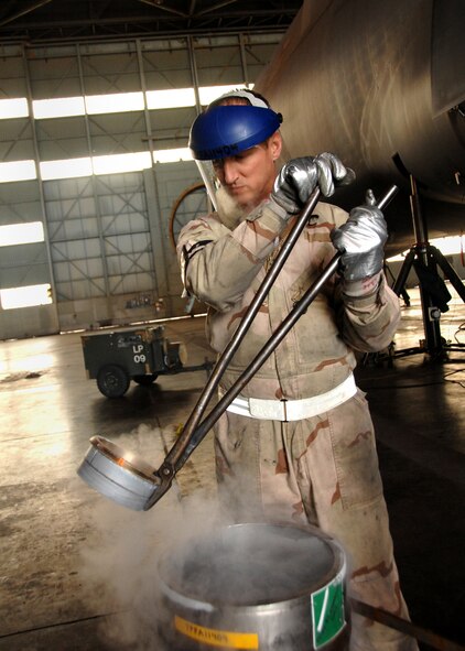 Mr. Charles Shaffer, member of the 349th Maintenance Squadron, prepares to freeze a main landing gear gudgeon bushing in liquid nitrogen. The liquid nitrogen compresses the bushing while it is being  installed. Once installed the bushing expands and stays tightly in place. (U.S. Air Force photo by Civ/Amanda Lopez)