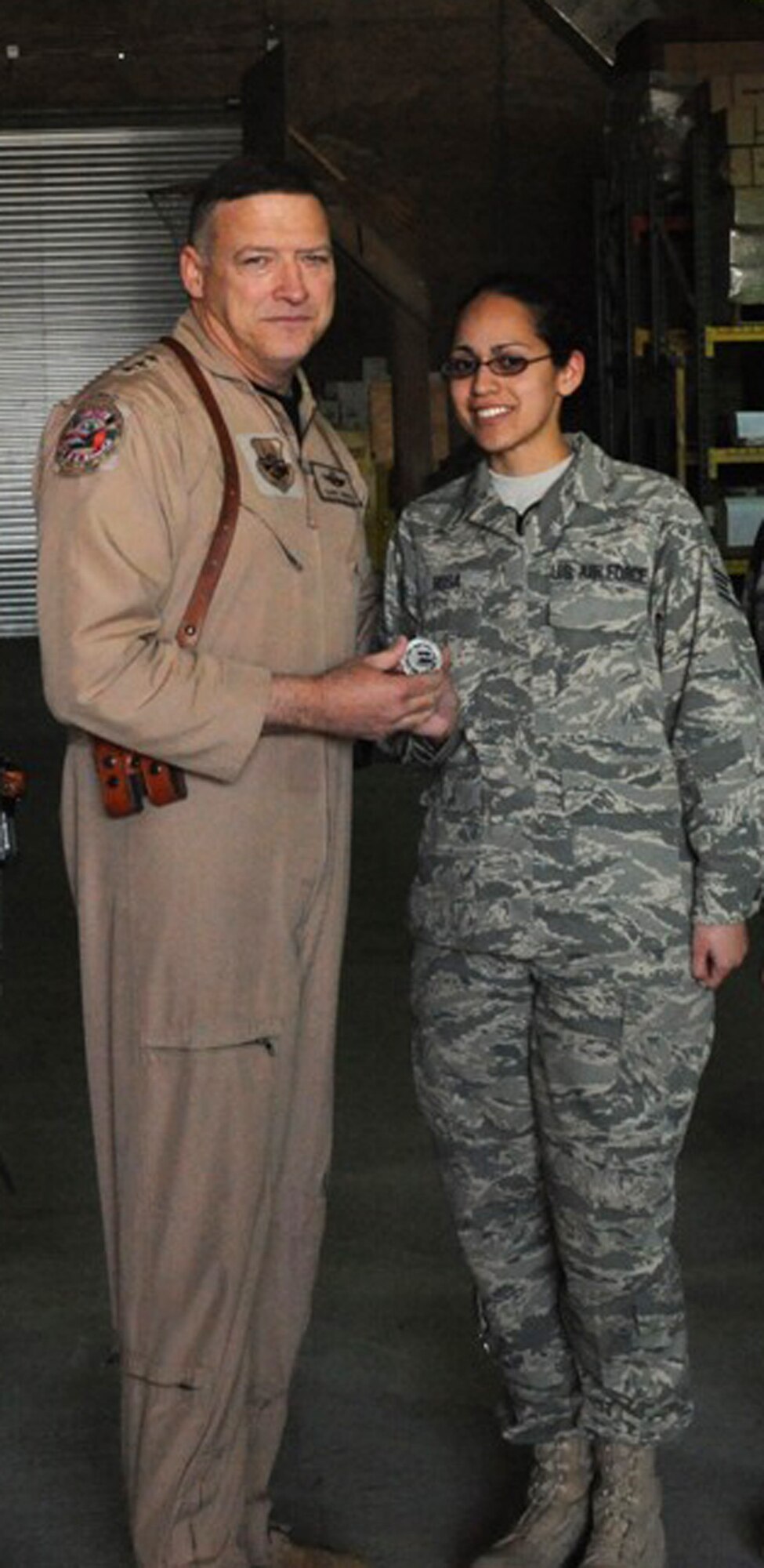 Staff Sgt. Shauna Rosa, Reservists from the 86th Aerial Port Squadron, McChord Air Force Base, Wash., receives a coin from Lt. Gen. Gary North, US Central Command commander.  Sergeant Rosa was recognized for her skills and wiliness to step forward.  She jumped in on her first shift at Joint Base Balad, Iraq and learned quickly the duties of ramp dispatch. Her clear, concise direction and coordination quickly became the model to follow.  She now trains others to dispatch for ramp nightshift.  Sergeant Rosa is one of 77 Reserve aerial port Airmen deployed from the 446th Airlift Wing at McChord. (U.S. Air Force photo)
