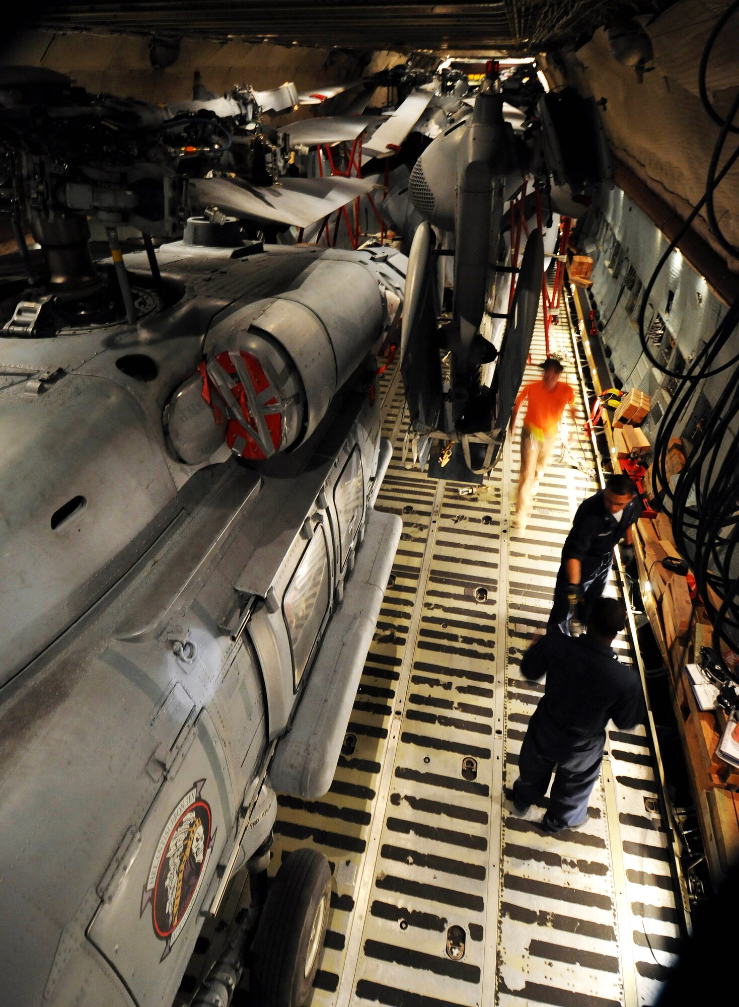 A load team conducts a final inspection after loading three MH-60S Knighthawk and two SH-60H Sea Hawk helicopters into a C-5 Galaxy March 13 on the flightline at Andersen Air Force Base, Guam.  Airmen from the West Virginia Air National Guard's 167th Airlift Wing and the 734th Air Mobility Squadron at Anderson Air Force Base, Guam, along with Sailors from Helicopter Sea Combat Squadron TWO-FIVE at Guam's A.B. Won Pat International Airport loaded the helicopters for transport to Naval Air Station North Island in San Diego.  (U.S. Air Force photo/Airman 1st Class Courtney Witt) 