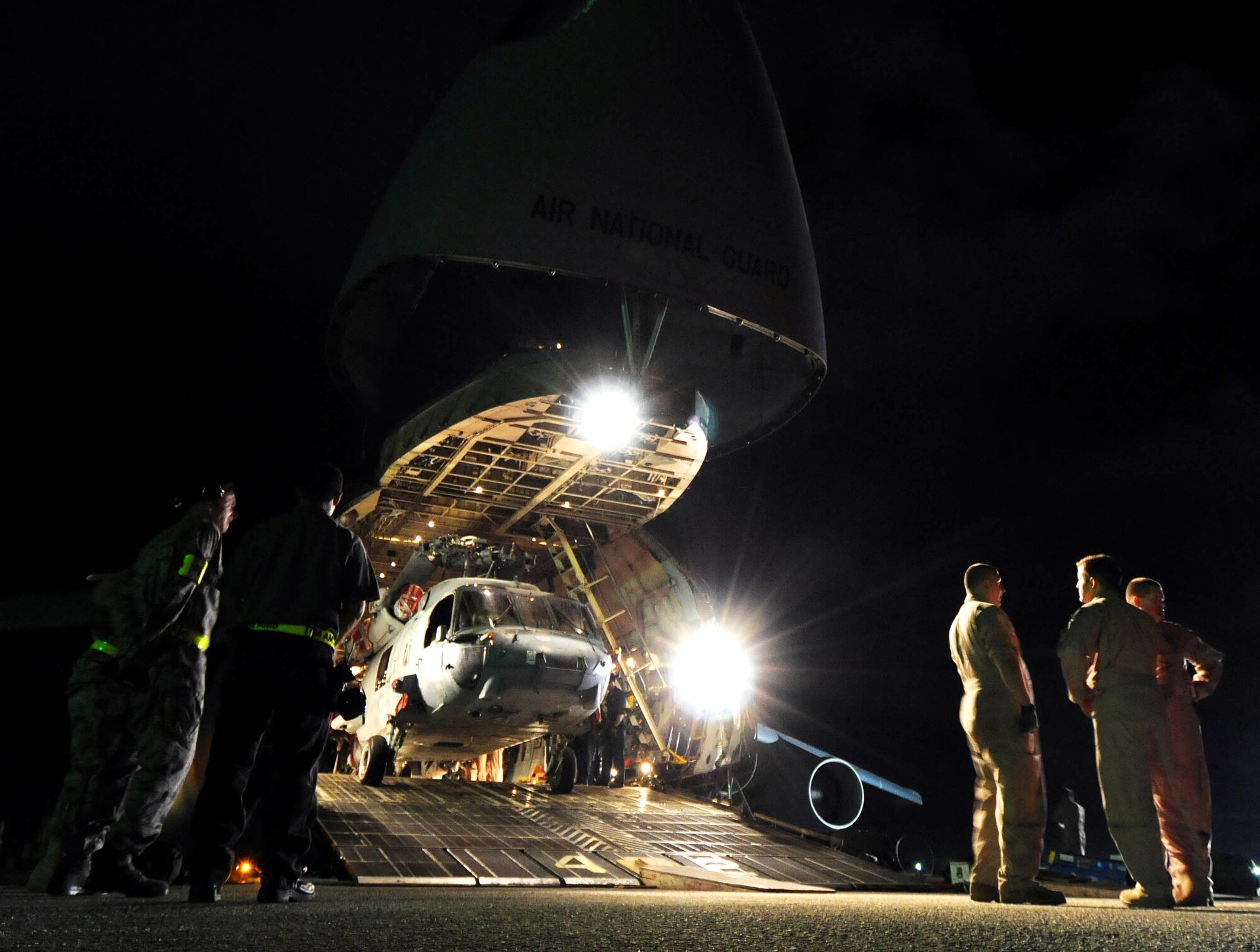 The aircrew of a C-5 Galaxy from the West Virginia Air National Guard's 167th Airlift Wing, discuss the complexities of loading five helicopters into their aircraft March 13 on the flightline at Andersen Air Force Base, Guam. Three MH-60S Knighthawks and two SH-60H Sea Hawks were being transported to Naval Air Station North Island in San Diego.  (U.S. Air Force photo/Airman 1st Class Courtney Witt)