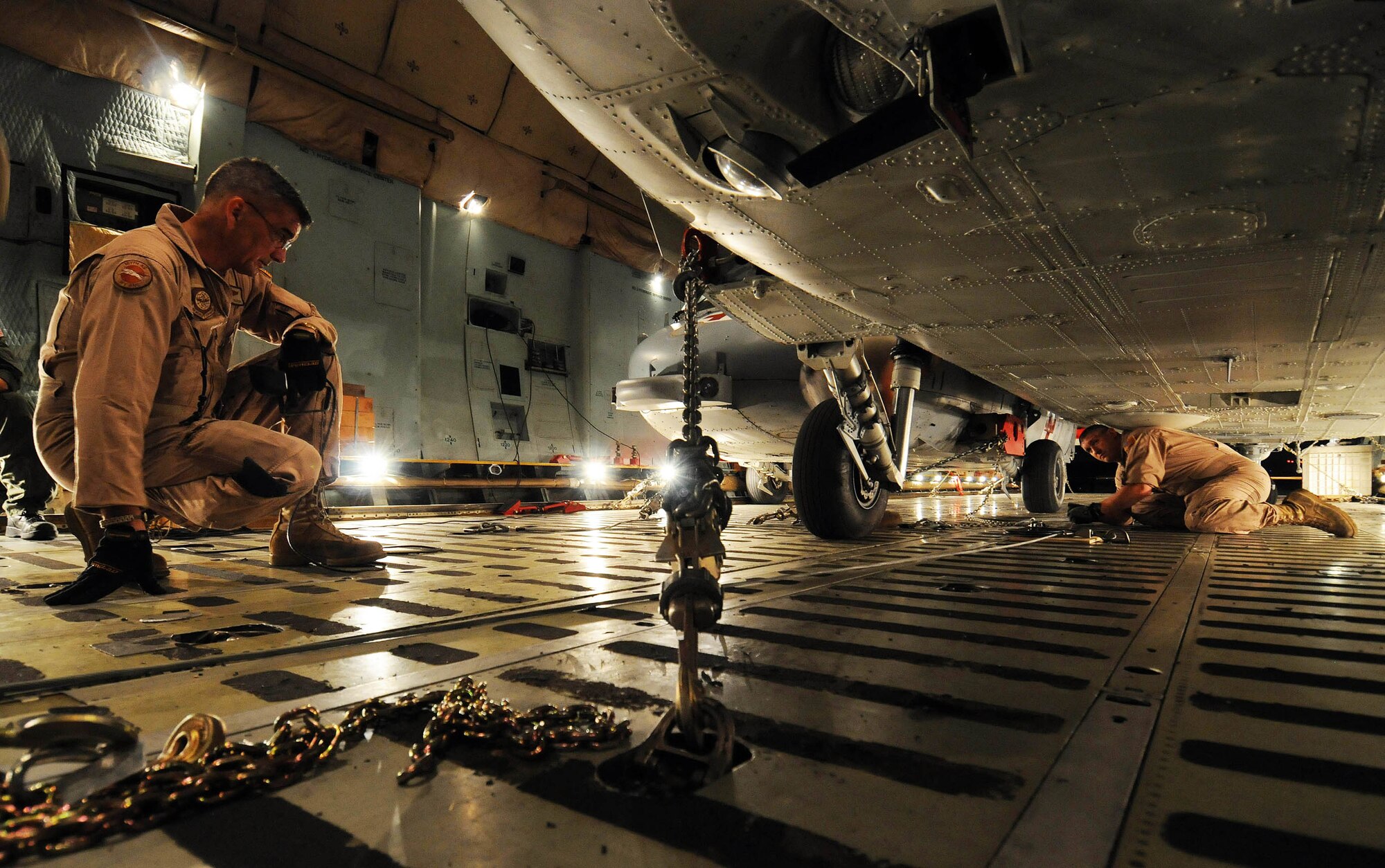 Senior Master Sgt. Randall Shafer, a loadmaster with the West Virginia Air National Guard's 167th Airlift Wing, observes as Staff Sgt. Justin McDonald ties down an MH-60S Knighthawk March 13 in the cargo bay of a C-5 Galaxy at Andersen Air Force Base, Guam. A team of Airmen from the 167th AW and the 734th Air Mobility Squadron at Andersen AFB and Sailors from Helicopter Sea Combat Squadron TWO-FIVE at Guam's A.B. Won Pat International Airport loaded three MH-60S and two SH-60H helicopters for transport to Naval Air Station North Island in San Diego.  (U.S. Air Force photo/Airman 1st Class Courtney Witt) 