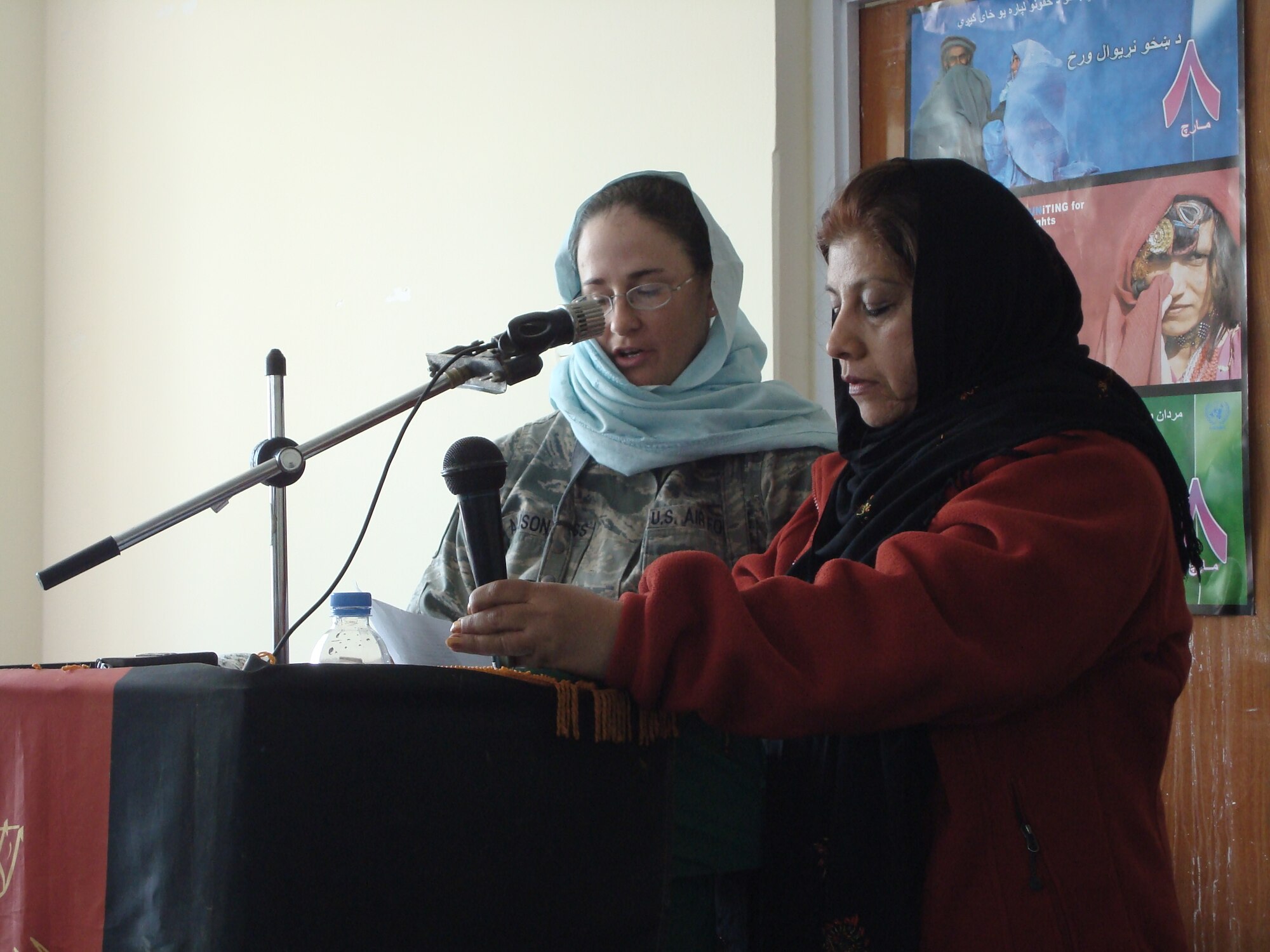 BAGRAM AIR FIELD, Afghanistan--Representing the Panjshir Provincial Reconstruction Team, Tech. Sgt. Dawn Allison-Hess, accompanied by interpreter Jamila, speaks with nearly 125 women and girls from Panjshir Valley who attended the March 8 International Women’s Day celebration in Bazarak District.  The audience heard from the province’s deputy governor and a former female Afghan judge.  A majority of the women wore burkas to the event, and once inside the Astana Guesthouse wore traditional head scarves.  Following the speeches, the audience feasted on a traditional Afghan lunch of pilau, a rice dish made with raisons and carrots, and conversed with one another.  Sergeant Allison-Hess is deployed from Goodfellow Air Force Base, Texas, and is the PRT's intelligence officer. (U.S. Air Force photo by Capt. Stacie N. Shafran)