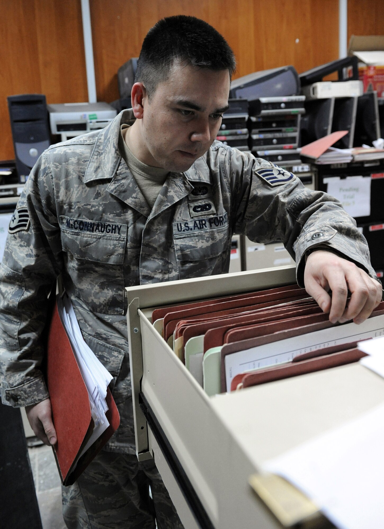 Staff Sgt. Adam McConnaughy sifts through case files March 3 in Baghdad, Iraq. Sergeant McConnaughy is a paralegal for the 732nd Central Criminal Court of Iraq. He is a  native of Sacramento, Calif., and is deployed from MacDill Air Force Base, Fla. (U.S. Air Force photo/Senior Airman Tiffany Trojca)