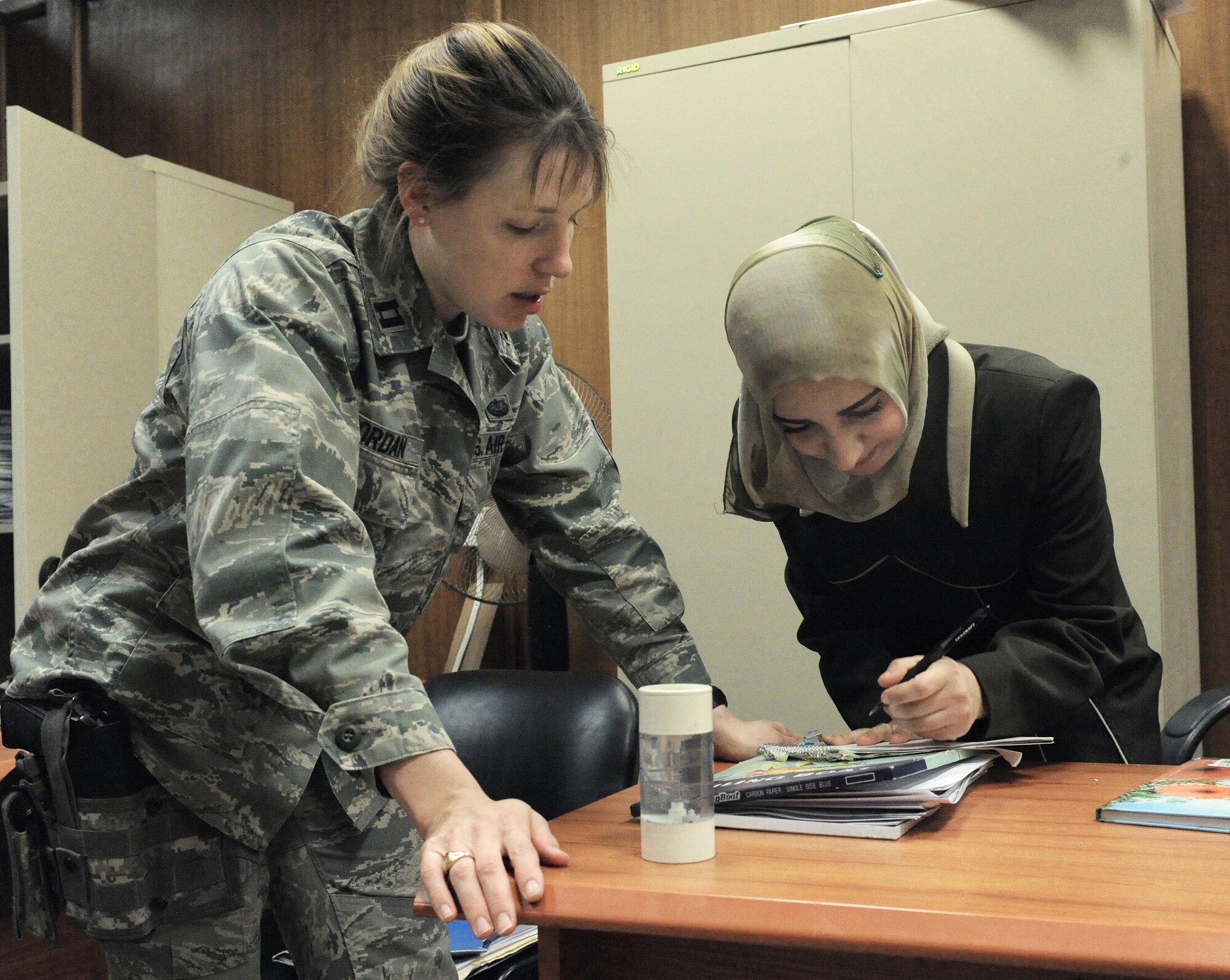 Capt. Karen Jordan and Iraqi investigator Athra'a look over legal files March 3 in Baghdad, Iraq. The investigators collect evidence and witnesses for trials. Captain Jordan is a lawyer for the 732nd Central Criminal Court of Iraq. She is a native of Raleigh, N.C., and deployed from Langley Air Force Base Va. (U.S. Air Force photo/Senior Airman Tiffany Trojca) 

