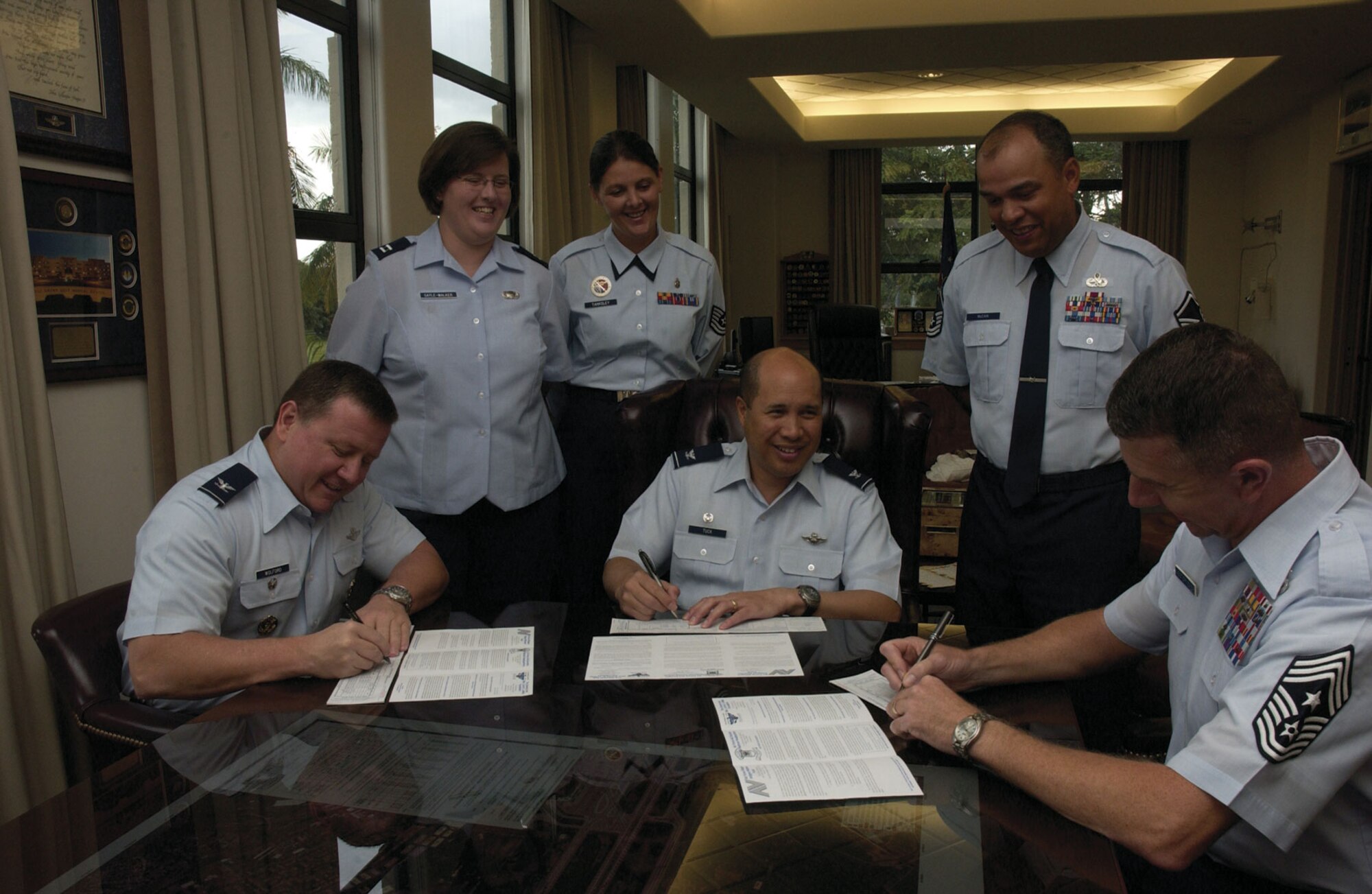 Seated, 15th Airlift Wing vice commander, Col. Dean Wolford, commander Col. Giovanni Tuck and Command Chief Master Sergeant Thomas Westermeyer dutifully endorse their payroll deduction forms for the Air Force Assistance Fund’s ‘Commitment to Caring’ campaign. Standing are Hickam coordinators Capt. Maritza Sayle-Walker, Tech. Sgt. Chrystal Tanksley and Master Sgt. Robert McCain.