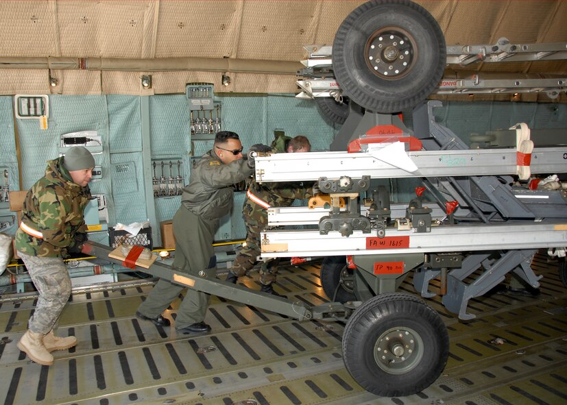 NY Air National Guard Staff Sgt. William Barney and Technical Sgt. Thomas Moade from the 174 FW and Staff Sgt. Felix Moya from the 105th AW  are loading a C-5A Galaxy from the 105th AW Newburgh, NY, at Hancock Field ANGB. The members were loading equipment for the 174th FW as the wing prepares for a deployment to Nellis AFB, NV in support of the Weapons Instructor Course. 174FW photo by SSgt Ricky Best