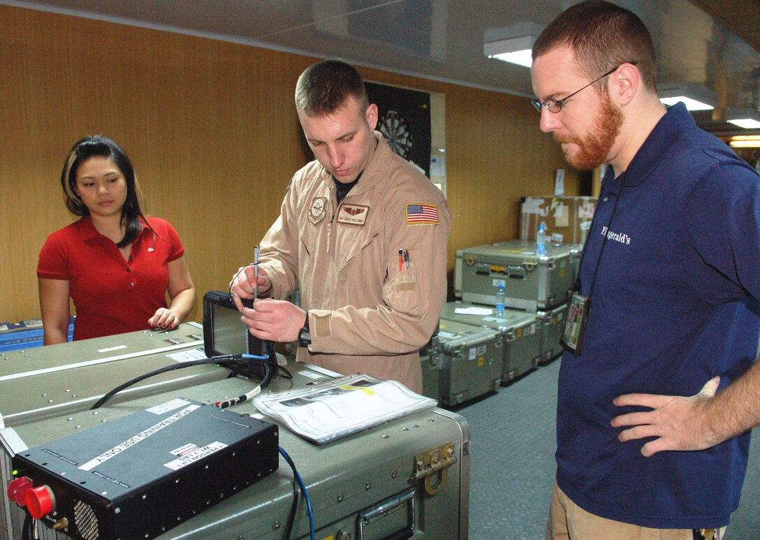 Senior Airman Chad Holloway learns how to boot up and operate the Roll-On-Beyond-Line-Of-Sight Enhancement System from Keith Lareau and Andrina Luczon March 13 at Manas Air Base, Kyrgyzstan. Airman Hollloway is a KC-135 boom operator deployed from the 92nd Air Refueling Squadron at Fairchild Air Force Base, Wash. Ms. Luczon and Mr. Lareau are Northrop Grumman contractors. (U.S. Air Force photo/Maj. Damien Pickart) 