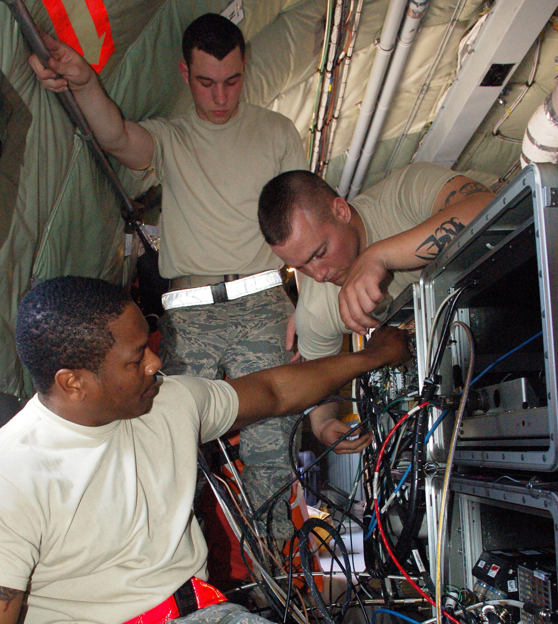 Airman 1st Class Joseph Robinson (front), Senior Airman William Allen (right) and Airman 1st Class Michael Burton help hook up the Roll-On-Beyond-Line-Of-Sight Enhancement System "B-kit" inside a KC-135 Stratotanker prior to a March 12 mission at Manas Air Base, Kyrgyzstan. Airman Robinson and Burton are both deployed from the 92nd Aircraft Maintenance Squadron at Fairchild Air Force Base, Wash. Airman Robinson is a native of McCoy, Miss., and Airman Burton is from New York City. Airman Allen is deployed from the 22nd Aircraft Maintenance Squadron at McConnell AFB, Kan., and is a native of Nunn, Colo. (U.S. Air Force photo/Maj. Damien Pickart) 