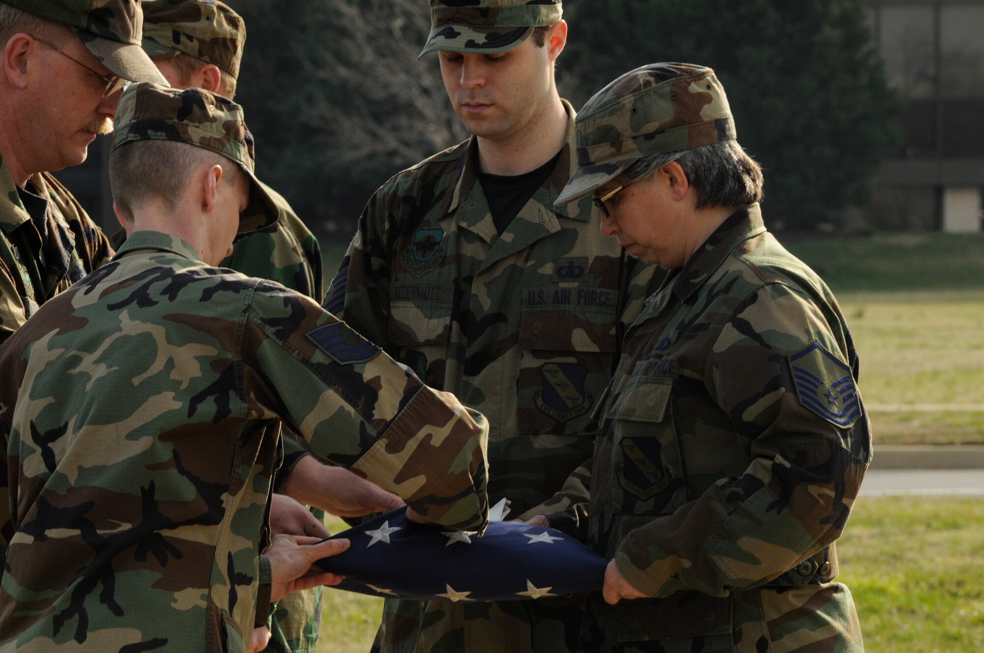 Members of the United States Air Force Band fold the flag March 18 during a retreat ceremony at the base flag pole. Due to the day light savings time change, retreat will be sounded daily at 5 p.m. The retreat ceremony signals the end of the official duty day and also serves as a ceremony for paying respect to the flag. Upon hearing the first note of retreat, military members in uniform should face the flag if visible or face the music if the flag is not visible and assume the position of parade rest. At the start of the National Anthem, military members in uniform should come to attention and salute until the anthem has ended. (U.S. Air Force photo by Staff Sgt. Dan DeCook)