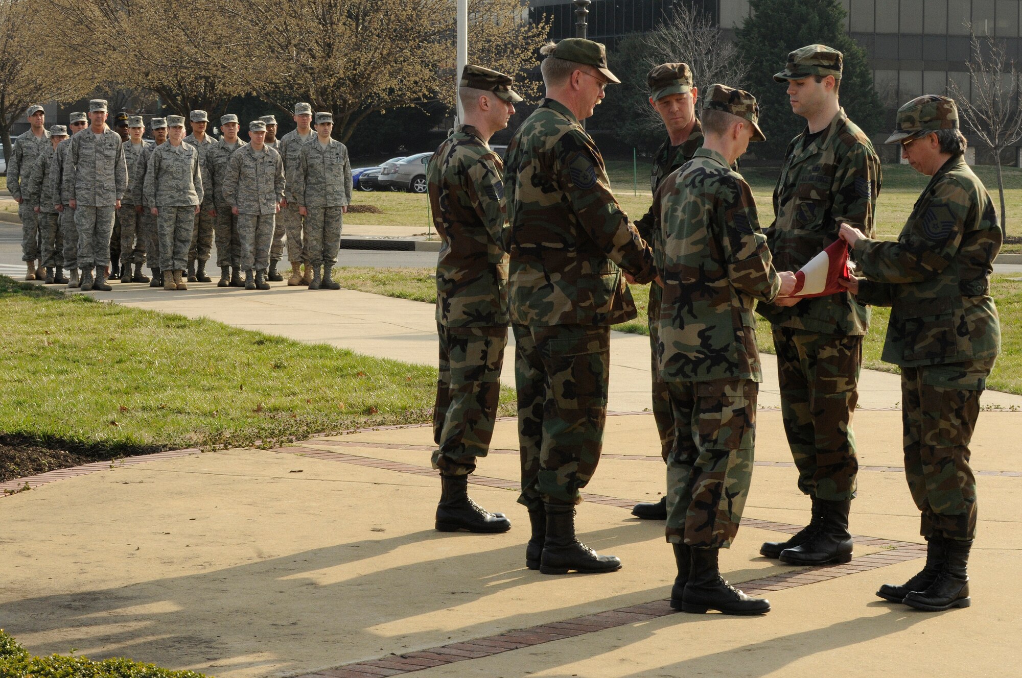 Members of the United States Air Force Band fold the flag March 18 during a retreat ceremony at the base flag pole. Due to the day light savings time change, retreat will be sounded daily at 5 p.m. The retreat ceremony signals the end of the official duty day and also serves as a ceremony for paying respect to the flag. Upon hearing the first note of retreat, military members in uniform should face the flag if visible or face the music if the flag is not visible and assume the position of parade rest. At the start of the National Anthem, military members in uniform should come to attention and salute until the anthem has ended. (U.S. Air Force photo by Staff Sgt. Dan DeCook)