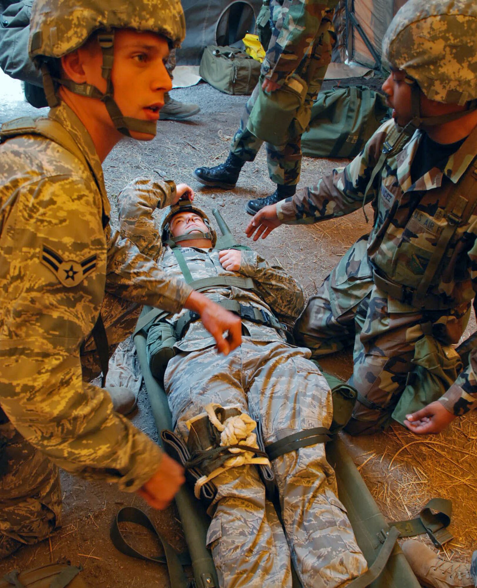 LAUGHLIN AIR FORCE BASE, Texas – Airman 1st Class Grant Dupill, 47th Operations Support Squadron, receives instruction on how to care for a mock gunshot wound while Staff Sgt. Thomas Fernandez, 47th Medical Operations Squadron, tends to the simulated patient, Senior Airman Jamie Flaherty, 47th Installation Support Squadron, during the Ability To Survive and Operate exercise here March 18. The ATSO exercise consisted of more than 50 Laughlin Airmen working together to sharpen their war-fighting skills by completing different scenarios they could possibly face in a deployed location. (U.S. Air Force photo by Airman 1st Class Sara Csurilla)