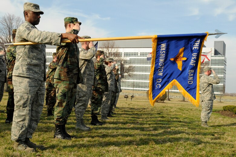 Members of the Air Force Band salute as the flag is lowered March 18 during a retreat ceremony at the base flag pole. Due to the day light savings time change, retreat will be sounded daily at 5 p.m. The retreat ceremony signals the end of the official duty day and also serves as a ceremony for paying respect to the flag. Upon hearing the first note of retreat, military members in uniform should face the flag if visible or face the music if the flag is not visible and assume the position of parade rest. At the start of the National Anthem, military members in uniform should come to attention and salute until the anthem has ended. (U.S. Air Force photo by Staff Sgt. Dan DeCook)