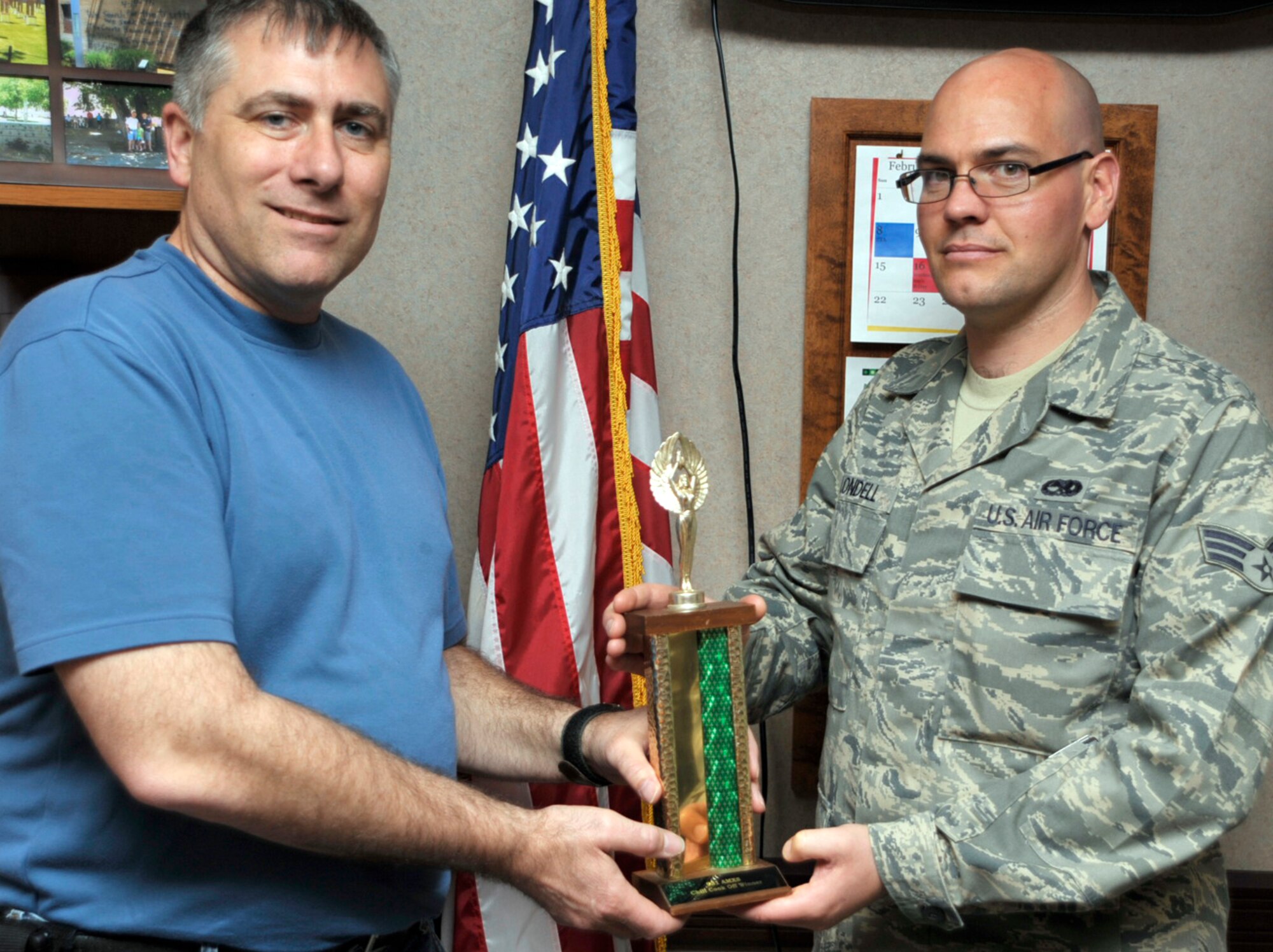 Senior Airman Daniel Blondell (on right) accepts the trophy for winning his squadron's 2009 chili cookoff. Airman Blondell is assigned to the Communications and Navigation shop of the 931st Aircraft Maintenance Squadron. Two other Airmen assigned to the squadron, Senior Master Sgt. Lloyd Campbell and Master Sgt. Paul McGinnis, won second and third place, respectively. Presenting the award is Tech. Sgt. Dave Sevart from the squadron's orderly room. (U.S. Air Force photo/Tech. Sgt. Jason Schaap)