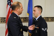 MINOT AIR FORCE BASE, N.D. -- Senior Airman Christopher McDonald, 791st Missile Security Forces Squadron, receives an Air Force Commendation Medal during a ceremony at the Jimmy Doolittle Center here March 20 for his actions Aug. 23, 2008, when he rendered assistance to individuals involved in a severe car accident. Airman McDonald performed cardiopulmonary resuscitation on the young girl who was injured in the accident and treated her for head wounds, ultimately saving her life. (U.S. Air Force photo by Senior Airman Kelly Timney)
