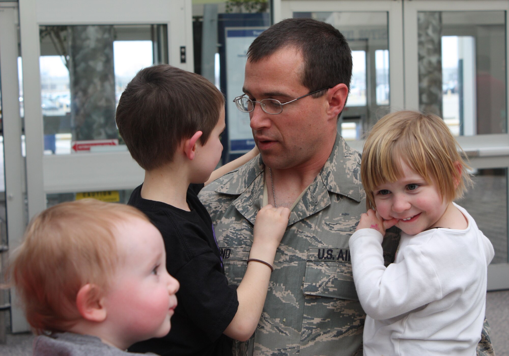 Staff Sgt. Dave Diamond, a trumpet player with the Air Force Band of Flight, reunites with his three children after completing a 60-day deployment. (Air Force photo by Maj. Mike Mench)