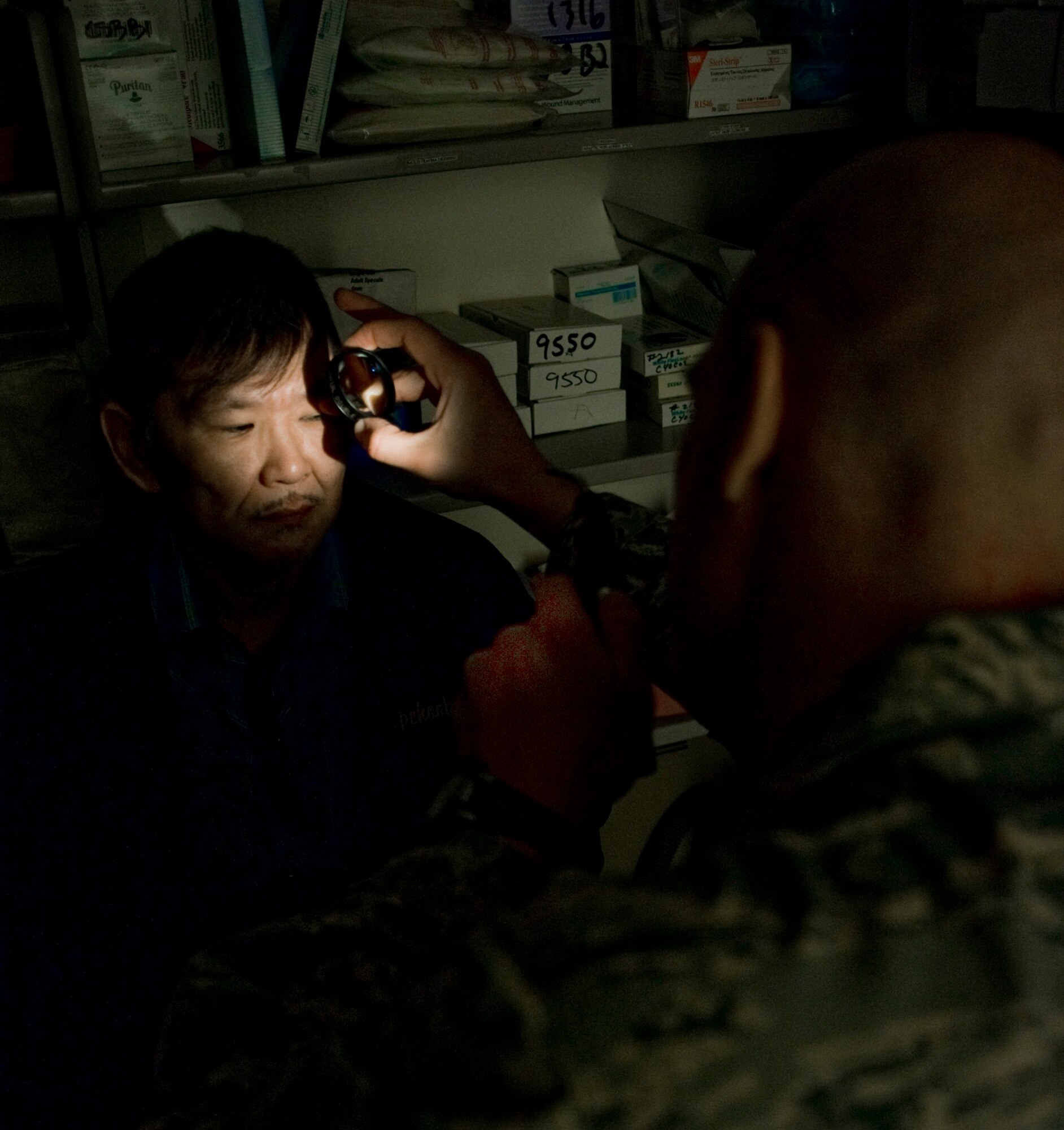 Capt. Justin Sandholmes, an optometrist from MacDill Air Force Base, Fla., examines a patient's cornea for abnormalities March 10 at a health clinic in Kwethluk, Alaska.  A joint military medical team deployed to Kwethluk, a small village in Western Alaska, in support of Operation Arctic Care 2009. This year's Navy-led mission had teams in 11 villages in Alaska's Yukon-Kuskokwim Delta region providing medical, dental and veterinary support at no cost to Alaskan natives. (U.S. Air Force photo/Senior Airman Christopher Griffin)