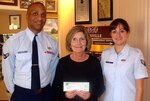 Airman 1st Class Jonathan Hunter (left), Team Randolph Airman's Council president,   and Senior Airman Carrie Faz, TRAC treasurer, present a check to Lenna Baxter, CEO of Boysville. The TRAC raised $200 and gave a $100 donation from the A+ Educational Organization to Boysville March 16. (Courtesy photo)                               