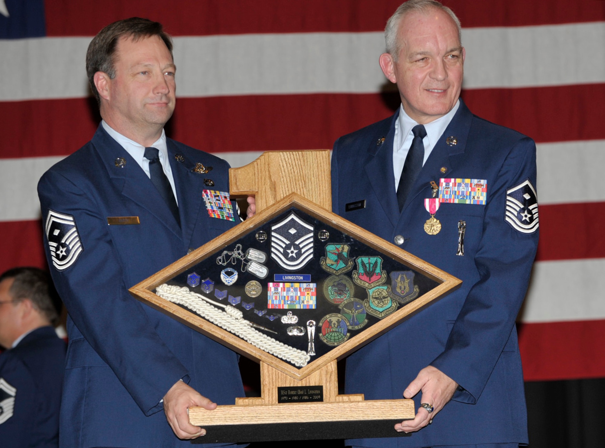 Senior Master Sgt. Ken Girty (on left) presents Master Sgt. Robert Livingston a display case filled with mementos of Sergeant Livingston's long Air Force career during his retirement ceremony on March 15. Sergeant Livingston was the first sergeant of three units within the 931st Air Refueling Group when he retired. Sergeant Girty is the first sergeant of the 18th Air Refueling Squadron, the flying unit of the 931st. (U.S. Air Force photo/Tech. Sgt. Jason Schaap)