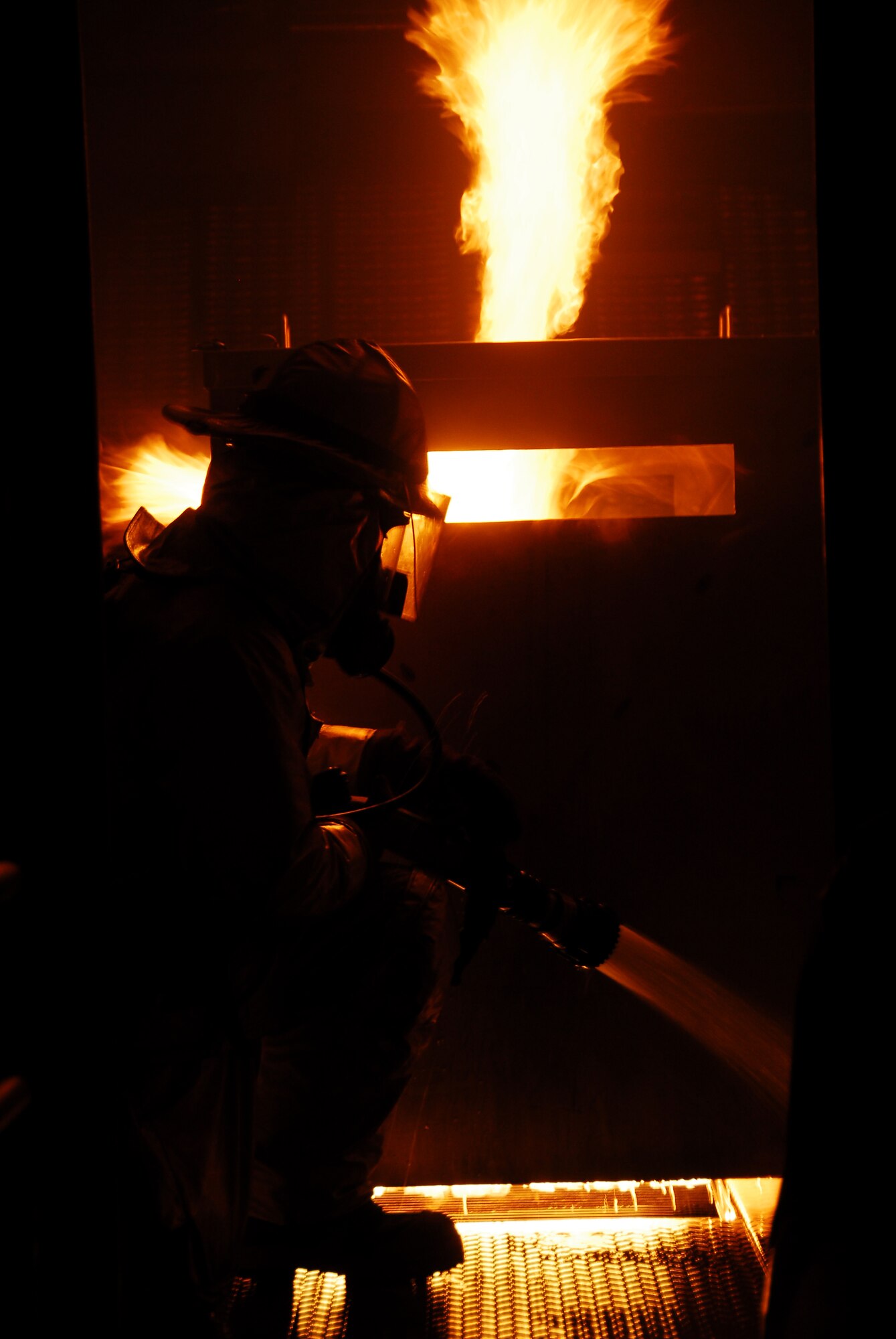 SOUTHWEST ASIA -- A 386th Expeditionary Civil Engineer Squadron firefighter flushes out an interior aircraft fire while searching for simulated injured passengers during live fire burn training at an Army base in Southwest Asia, March 18. The training allows the firefighters to familiarize themselves with nozzle operations, builds proficiency, morale and teamwork. (U.S. Air Force photo/ Senior Airman Courtney Richardson)